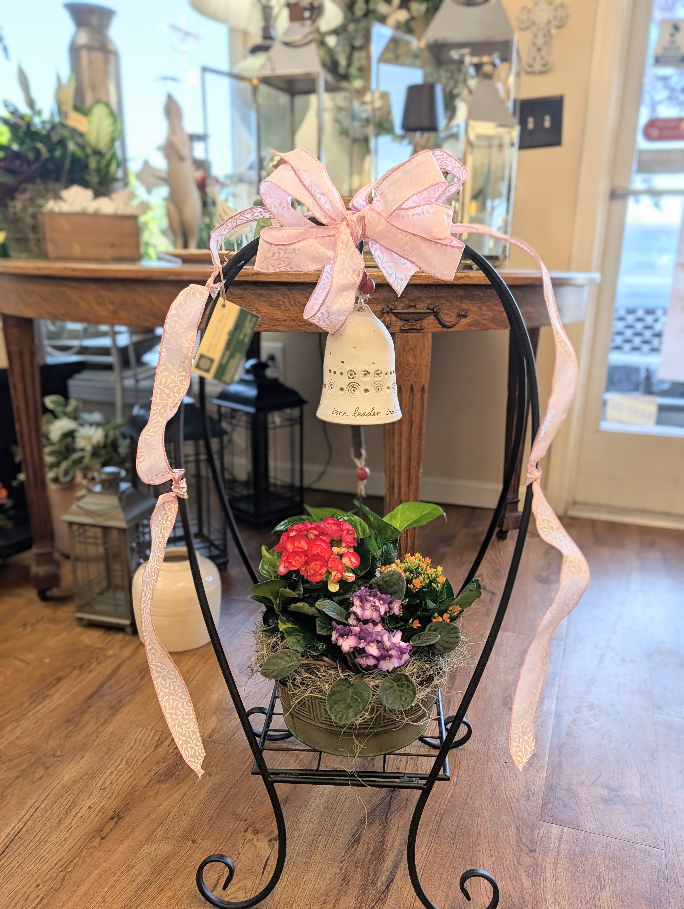 Bountiful Blooms Plant Garden  - Moss' Bountiful Blooms Plant Garden includes a mixture of both blooming and green plants accented with a bow.  Arrives in decorative plant stand, accent bow and ceramic bell with text "Born Leader"
