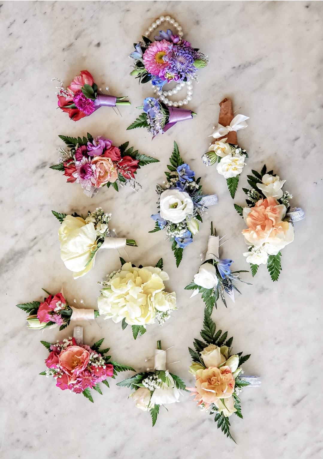 Assorted floral boutonnieres and corsages with ribbon accents