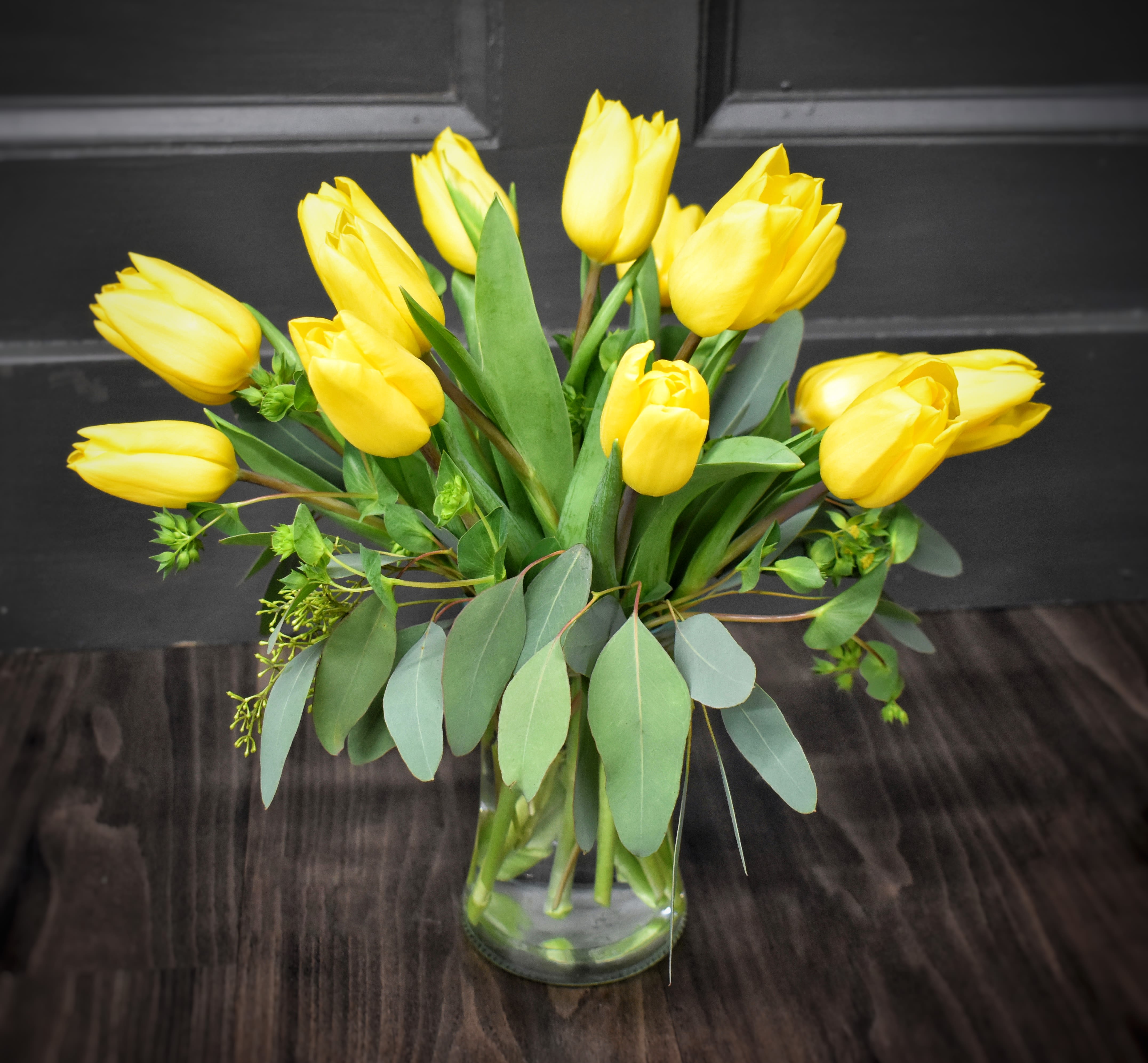 Yellow tulips arranged in a clear glass vase