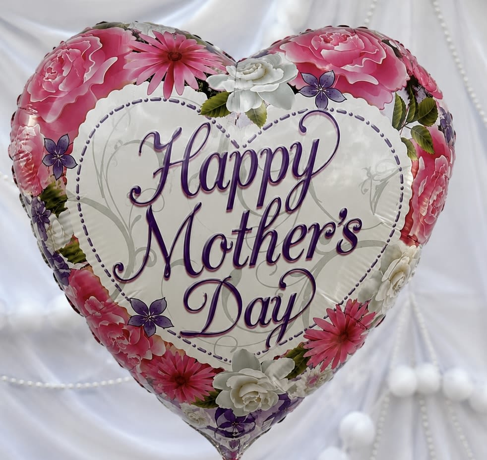  BALLOON MOTHERS DAY (HEART SHAPED) - A glossy heart-shaped foil balloon printed with "Happy Mother's Day" in flowing purple script makes a cheerful, celebratory centerpiece for Mother's Day or any moment you want to show appreciation. The bold purple message is framed by a delicate border of illustrated pink, white, and purple flowers with touches of green-giving the balloon a soft, feminine look that reads as thoughtful and festive without needing real blooms.  Lightweight and ready to float, this decorative foil balloon is the kind of gift that makes the person you're celebrating smile the moment they see it. Perfect alone as a surprise on a breakfast tray, tucked into a gift package, or paired with treats, it keeps the sentiment simple and visible. Order sizing and inflation options are available at checkout; avoid sharp objects and keep away from open flames to preserve the glossy finish and floating life.