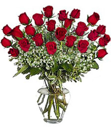 Tall arrangement of red roses with white filler flowers in a clear glass vase