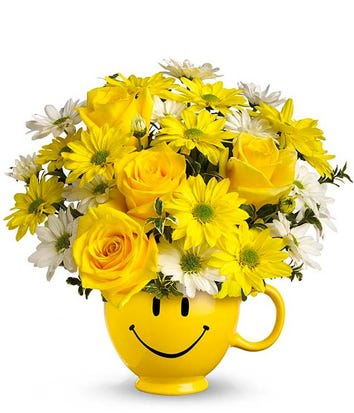 Yellow roses and daisies in a smiley-face mug