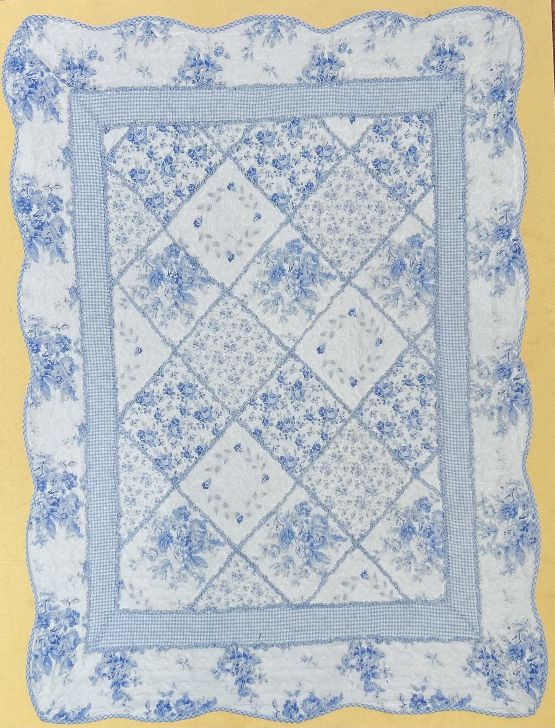 Blue and white quilted pillow with floral patchwork pattern