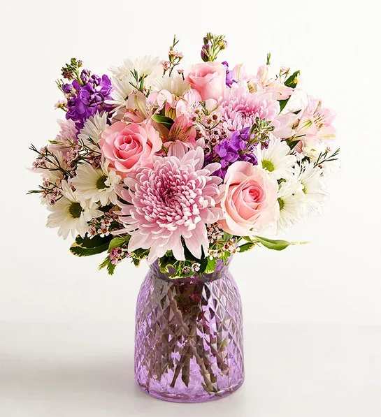 The Amazing Mom Bouquet - You know she’s amazing; now show her that you know. Roses, Peruvian lilies, daisy poms, and other lush blooms arrive artfully arranged in a lavender glass vase for a bouquet as beautifully splendid as she is.