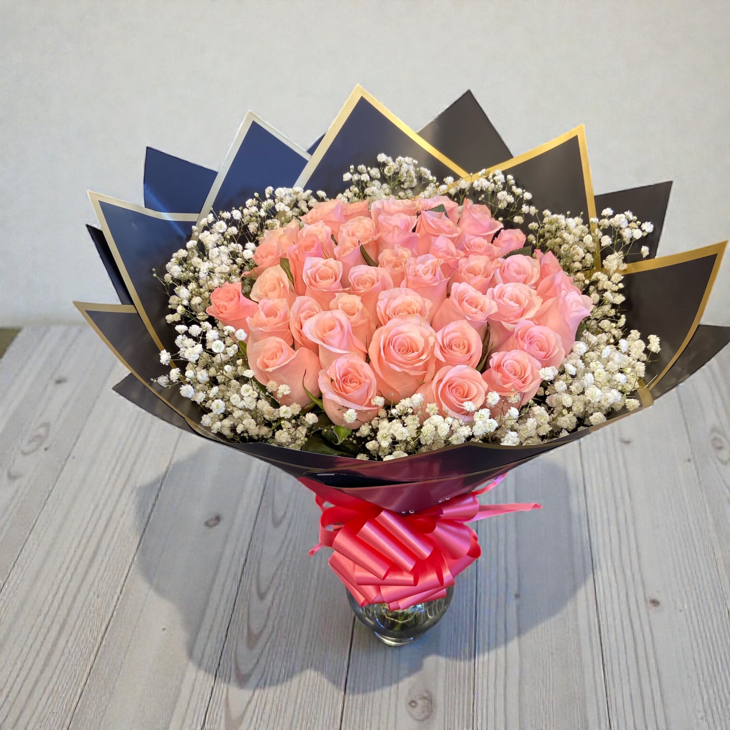 Bouquet of pink roses with white baby's breath in a glass vase