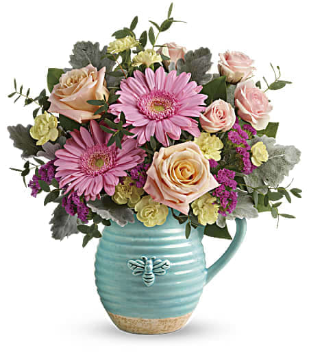 Pink gerberas and peach roses in a turquoise pitcher vase