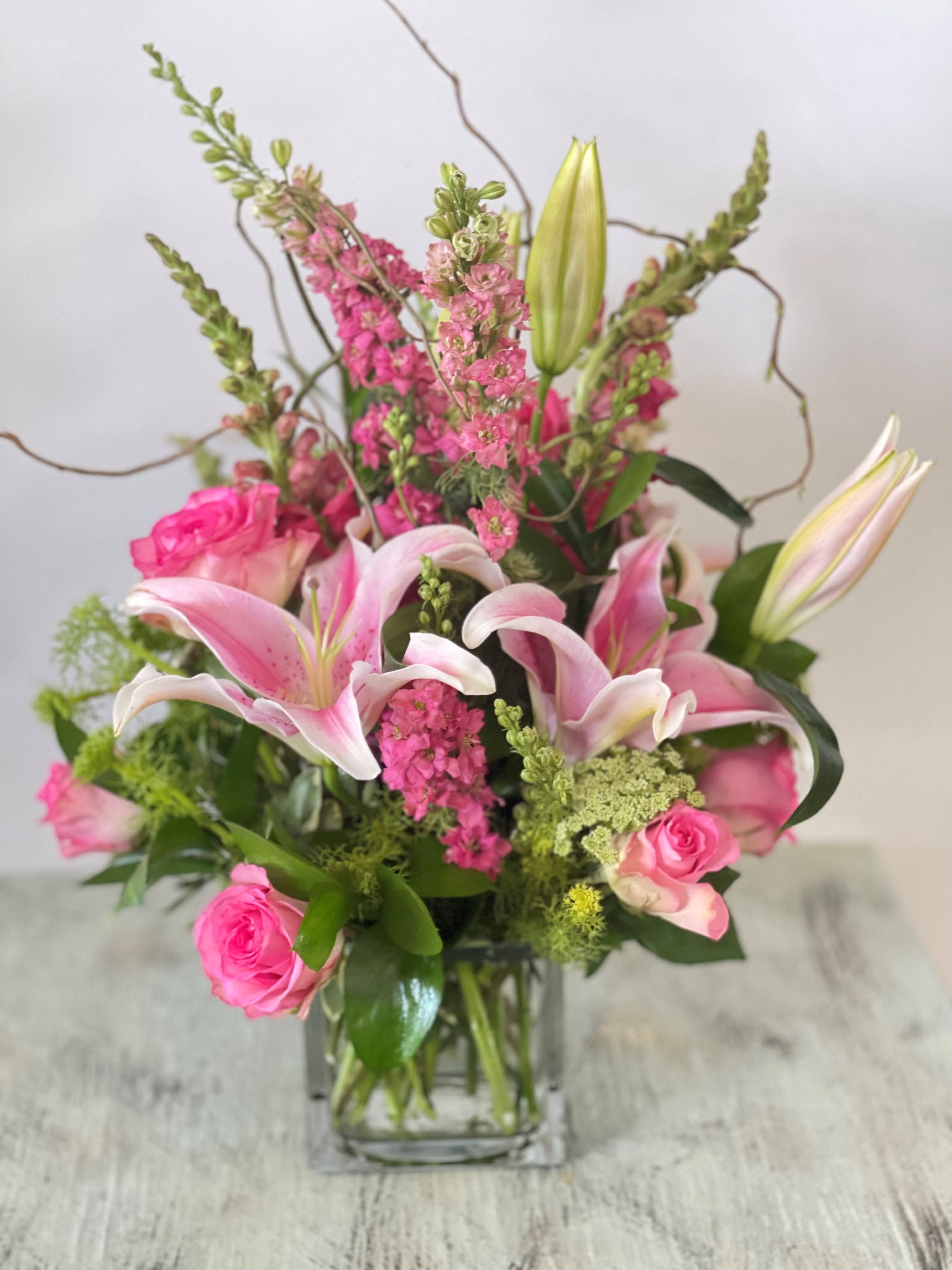 Anniversary #4 - All pink arrangement of fresh cut flowers designed in a clear glass cube vase. Colors can be modified depending on availability.