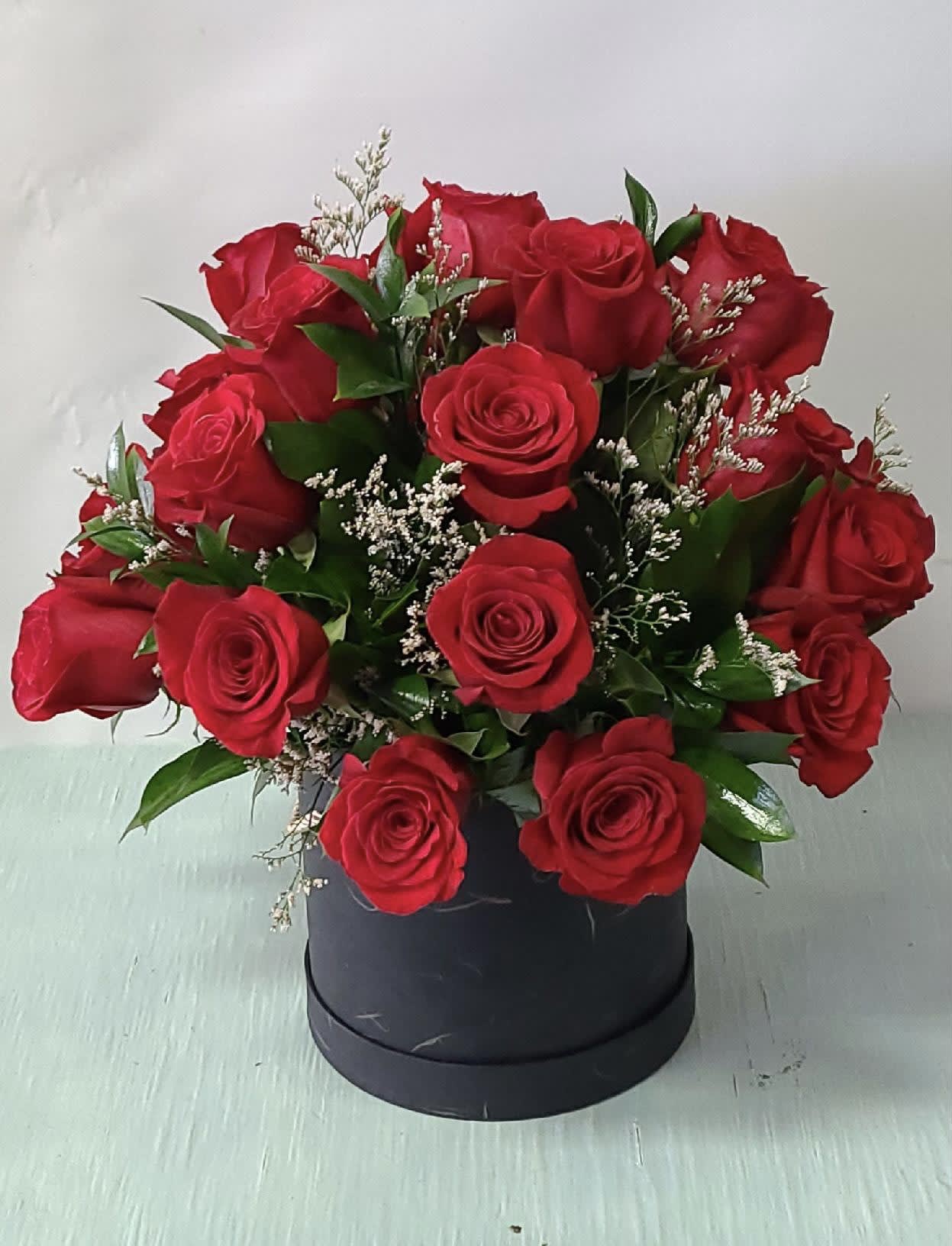 Bouquet of red roses in a black round box