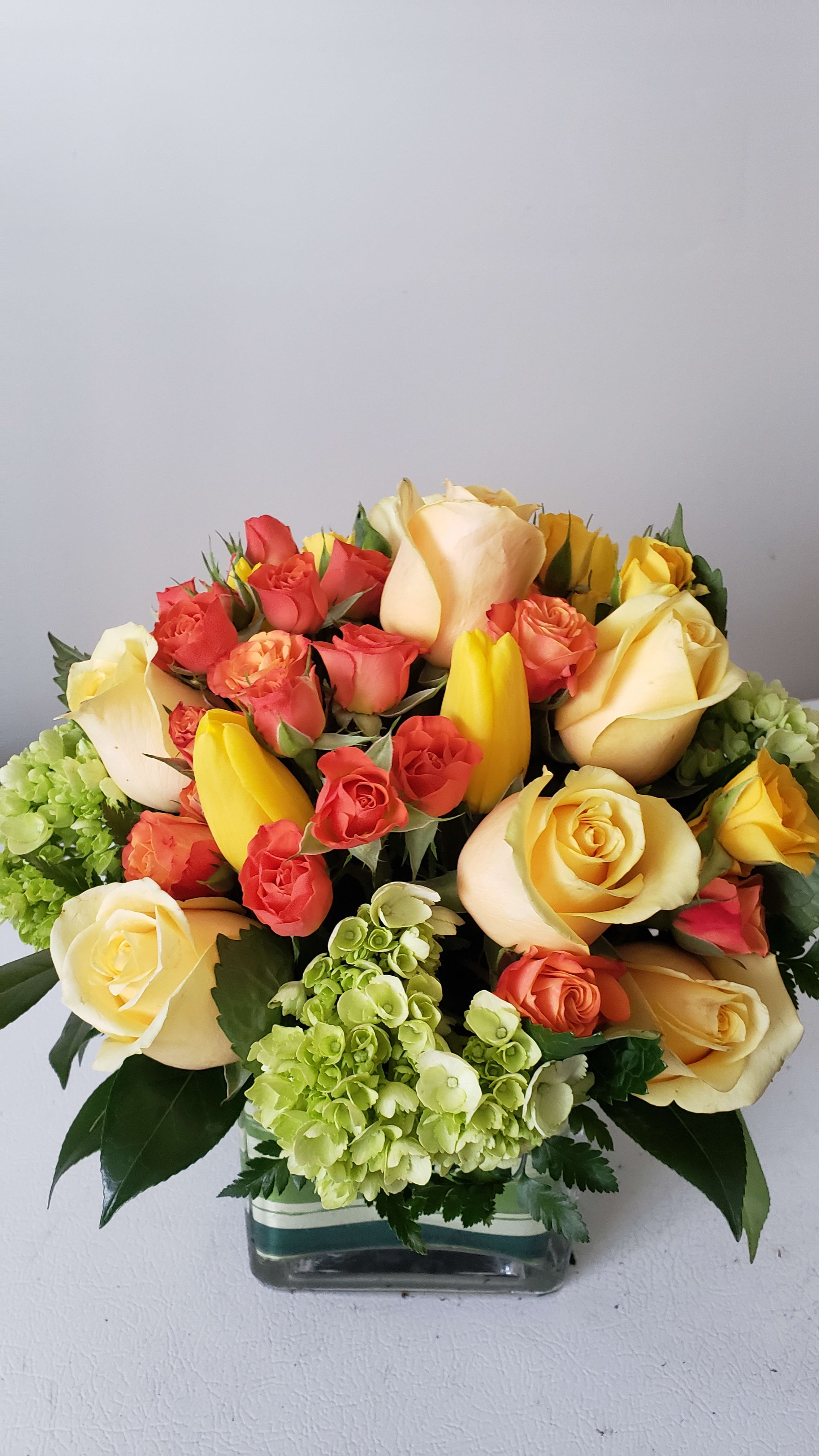 Mixed roses and tulips arranged in a glass vase