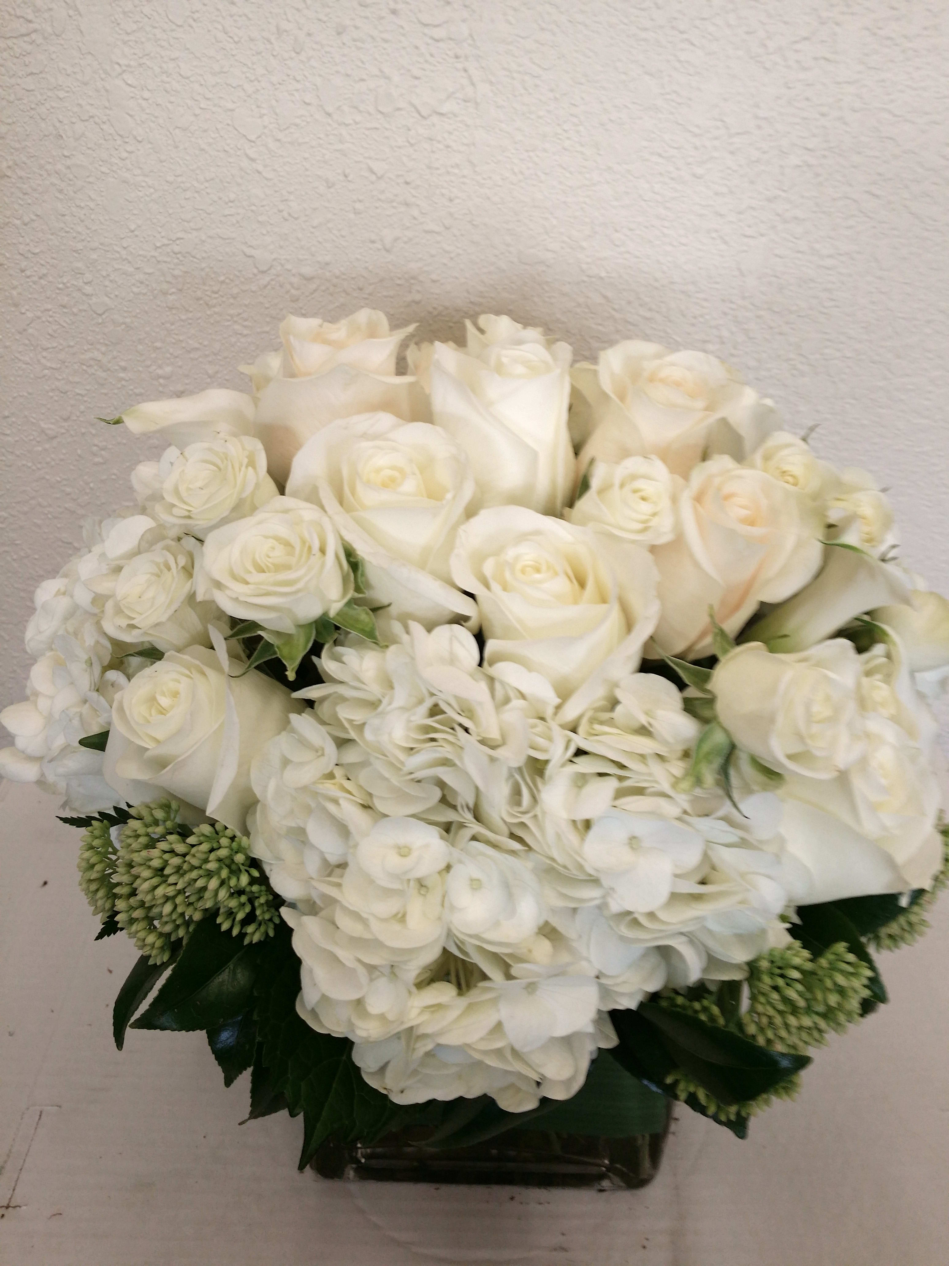 White roses and hydrangeas arranged in a low vase