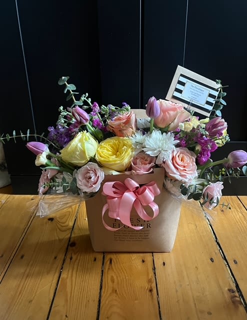 Mixed pastel flower arrangement in a square box with a pink ribbon