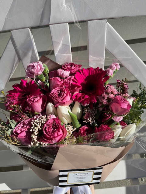 Pink and white mixed bouquet wrapped in paper and clear plastic