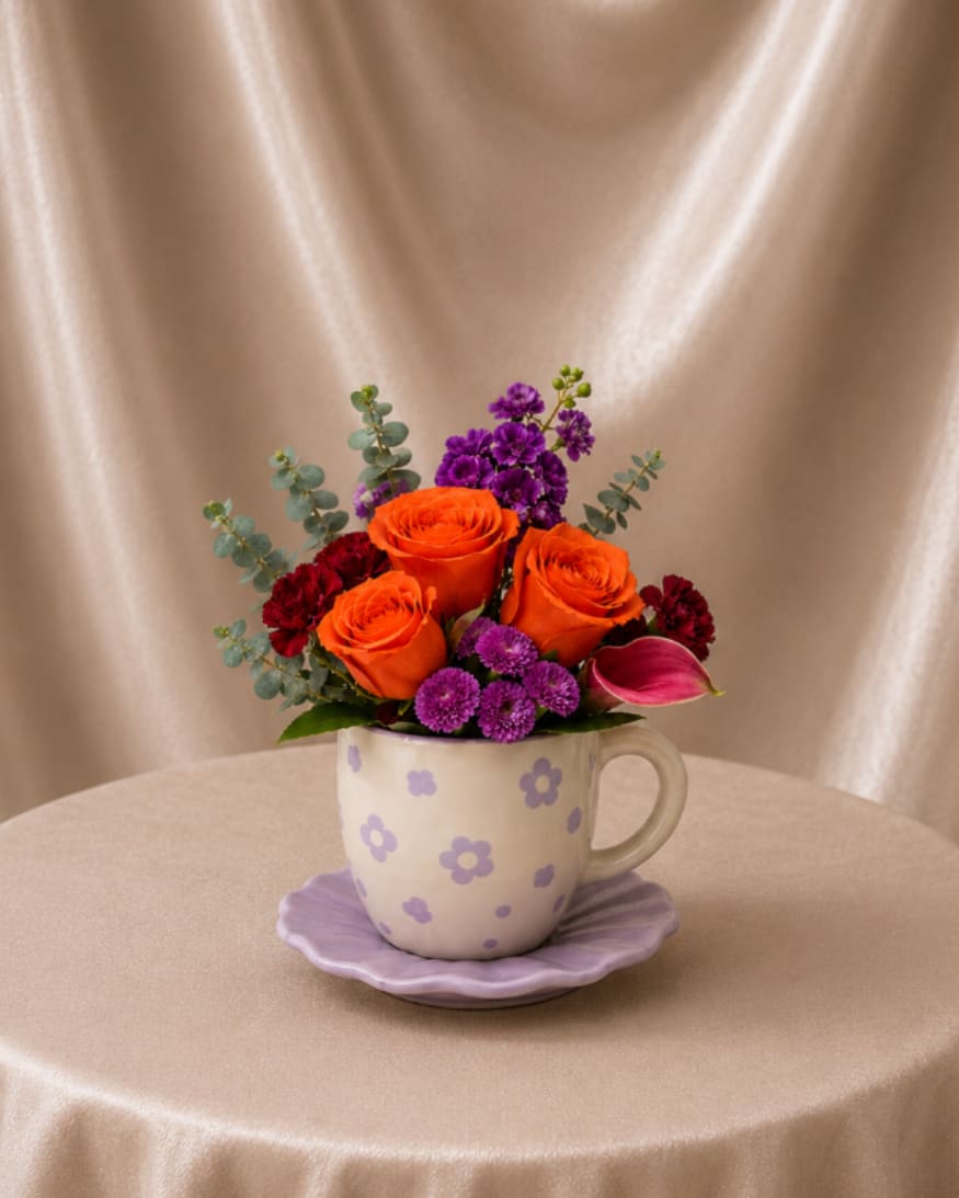 Sweet Garden Cup - A charming floral arrangement designed in a sweet keepsake cup and saucer. Bright seasonal blooms and fresh greenery create a cheerful garden-inspired design that brings warmth and joy to any space.  Better For: Birthdays, Spring celebrations, Easter, Thank you, Get well, Just because.   Flowers and keepsake cup may vary based on availability. Our designers will select the freshest blooms while maintaining the same overall style, color palette, and feel of the arrangement.