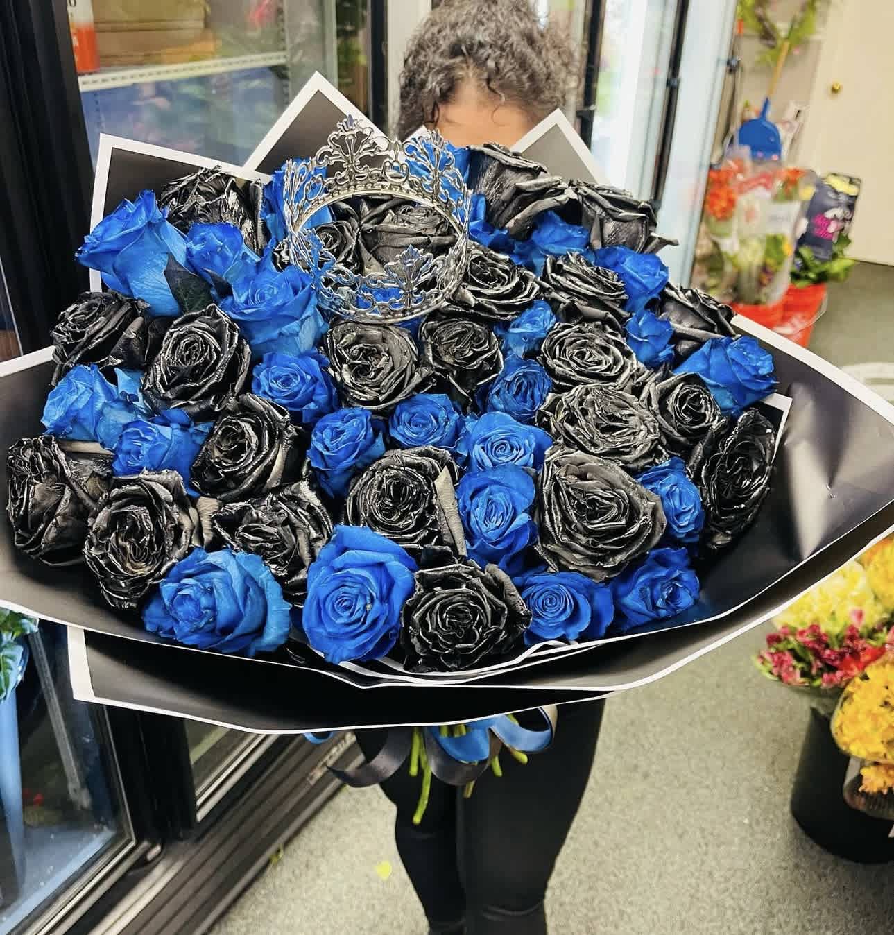 Bouquet of blue and black roses with a silver crown topper