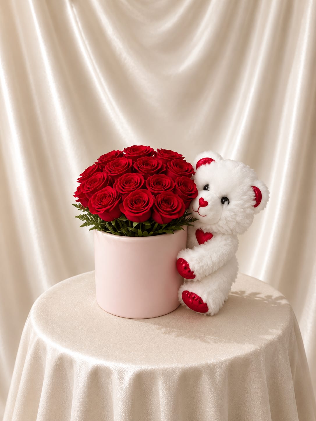 Rose Hat Box with Teddy Bear - A romantic arrangement of fresh red roses designed in a chic blush hat box, paired with a soft white teddy bear. A sweet and elegant gift that combines flowers and plush for the perfect heartfelt surprise.  Each piece is Designer’s Choice, created with fresh seasonal blooms. Flowers and colors may vary based on availability while maintaining the overall style and quality.   Better for: Valentine’s Day, anniversaries, romantic surprises, birthdays, I love you gifts, just because.