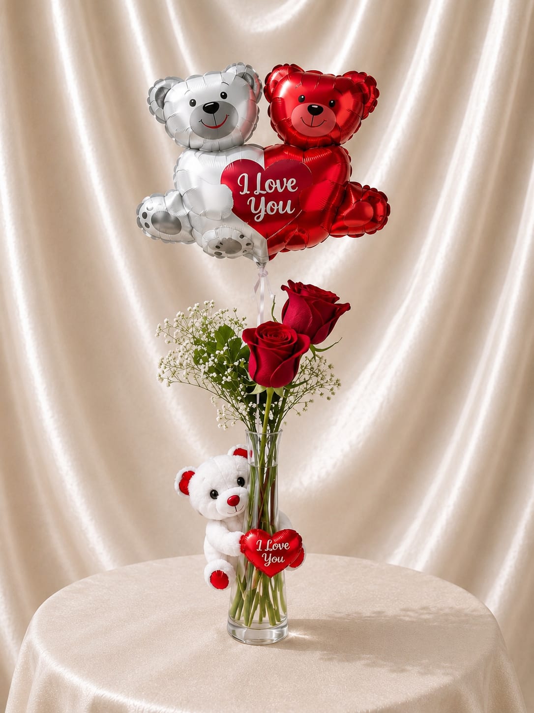 Red roses in a glass vase with teddy bear balloons and a small plush bear