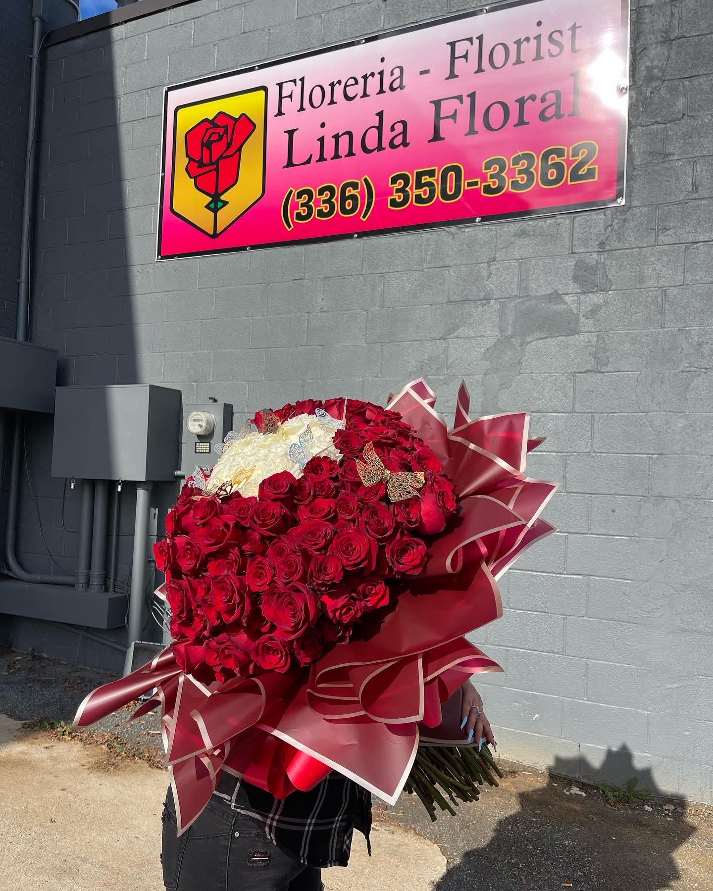 Large bouquet of red and white roses wrapped in burgundy paper