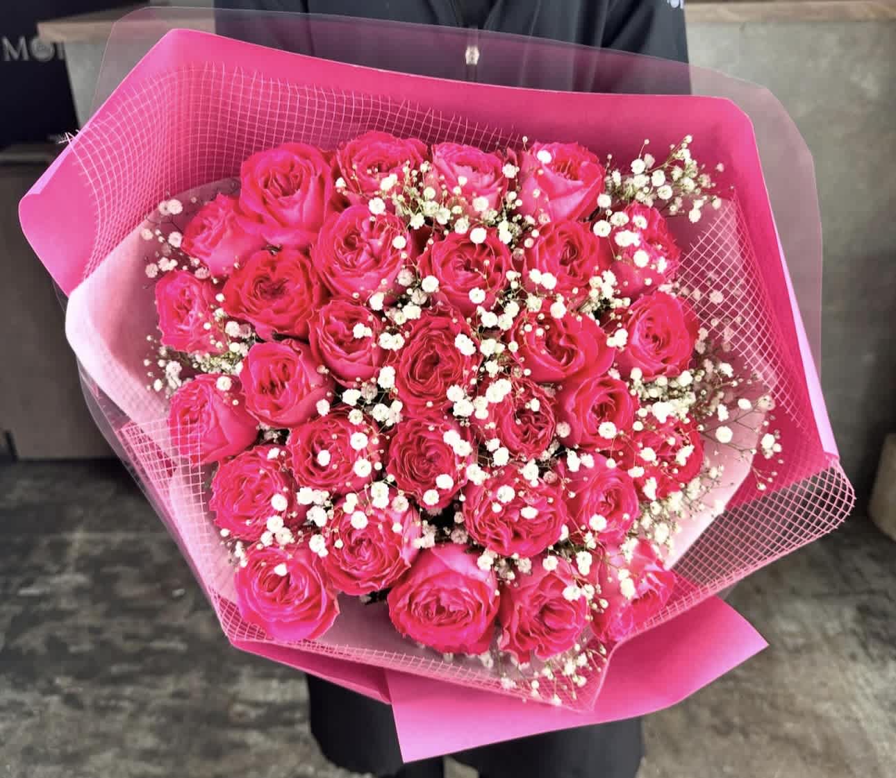 Bouquet of hot pink roses with baby's breath wrapped in pink paper