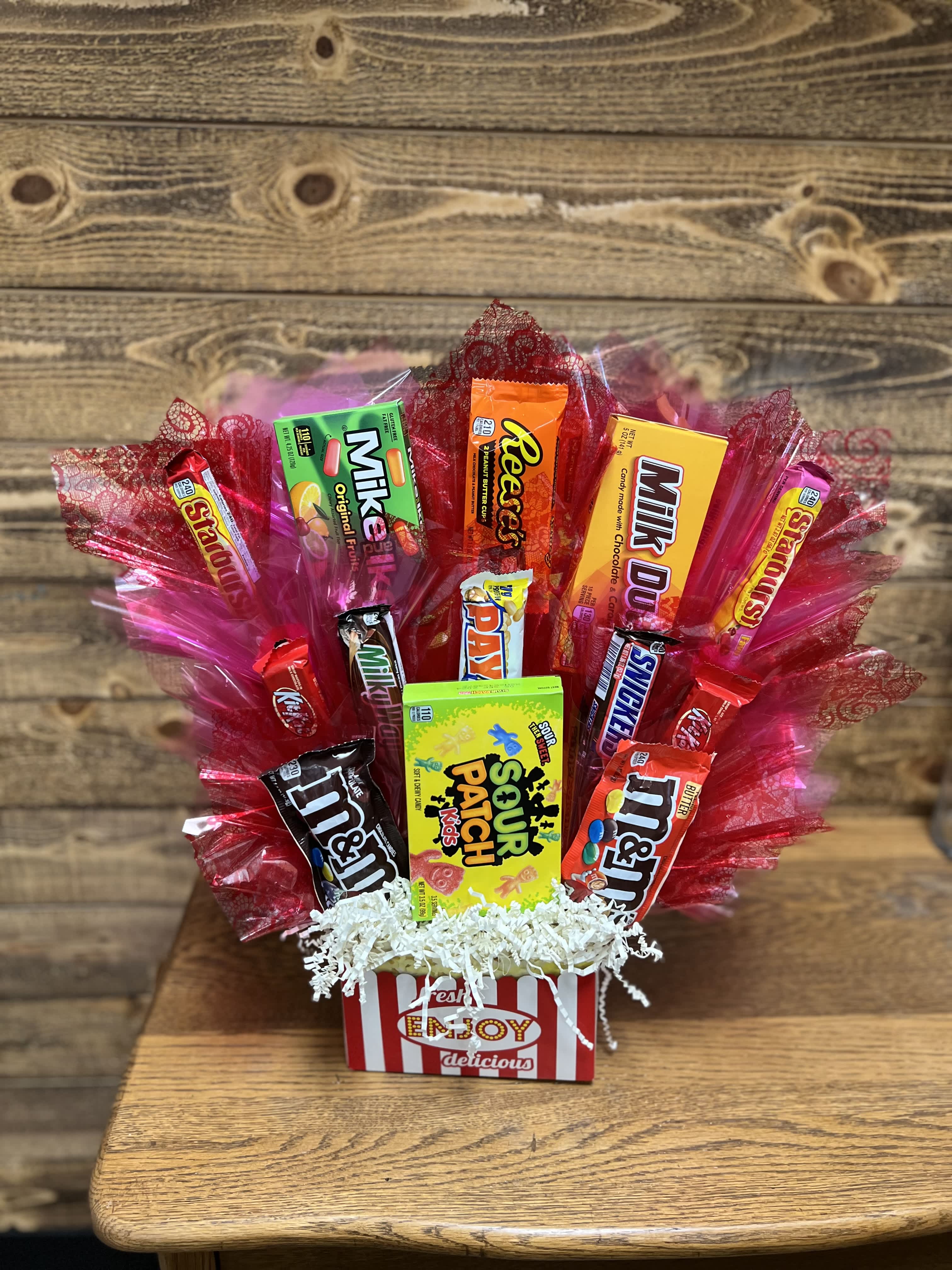 Candy bouquet in a striped box with red cellophane wrapping