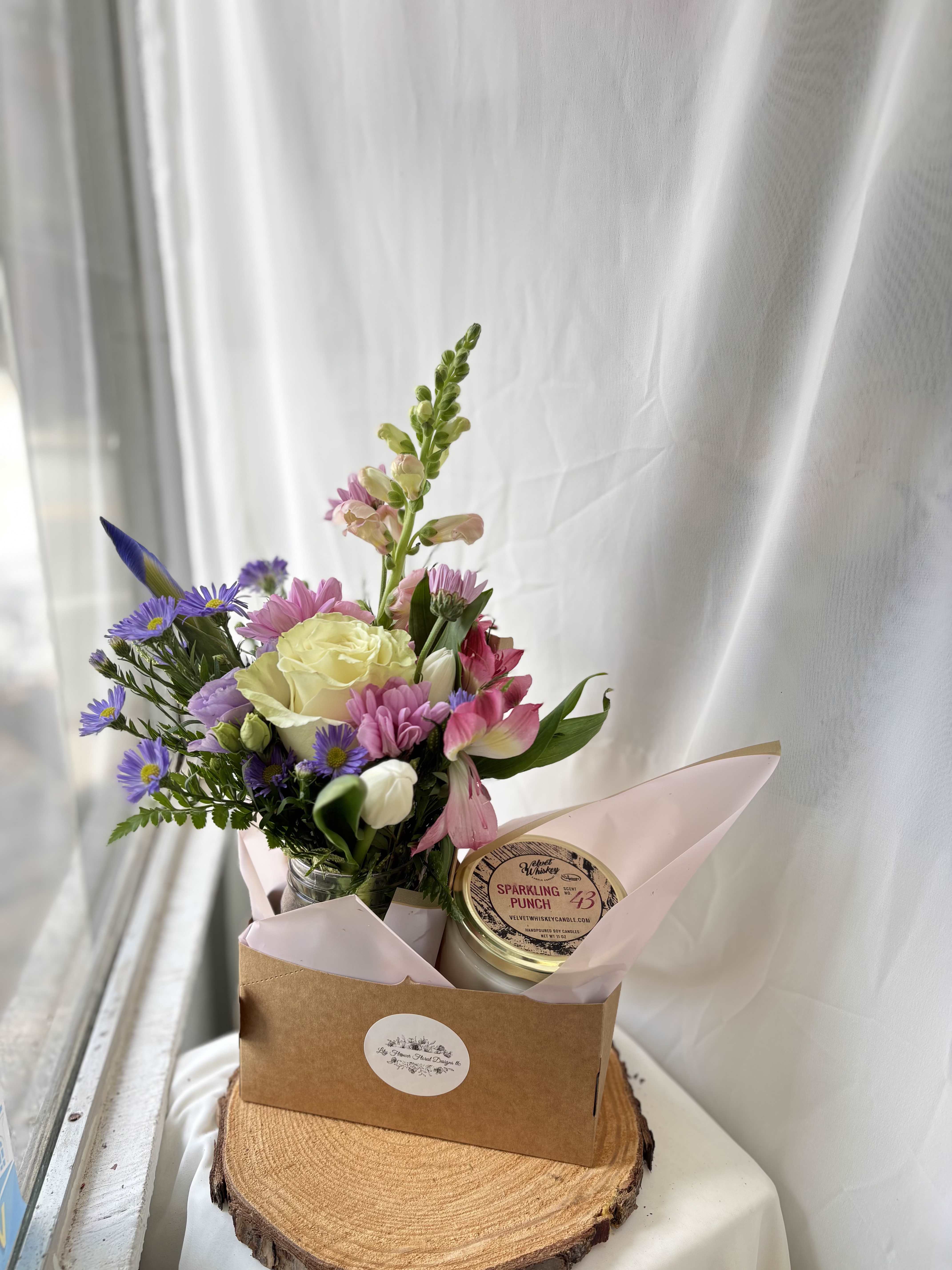 Mother's Day Bundle - This arrangement is perfect for an important Woman in your life! Featuring colorful blooms arranged in a vase, paired with a candle of your choice! We cannot guarantee the same colors and varieties of flowers pictured, but it will give the same style and feel! Let us know if there are any specific colors or varieties of flowers you have in mind, we will try our best to accommodate! Scent Options: Sparkling Punch Tranquil Campfire Warm Cider Bouquet of Flowers Leave your scent preference in the notes section at checkout! 