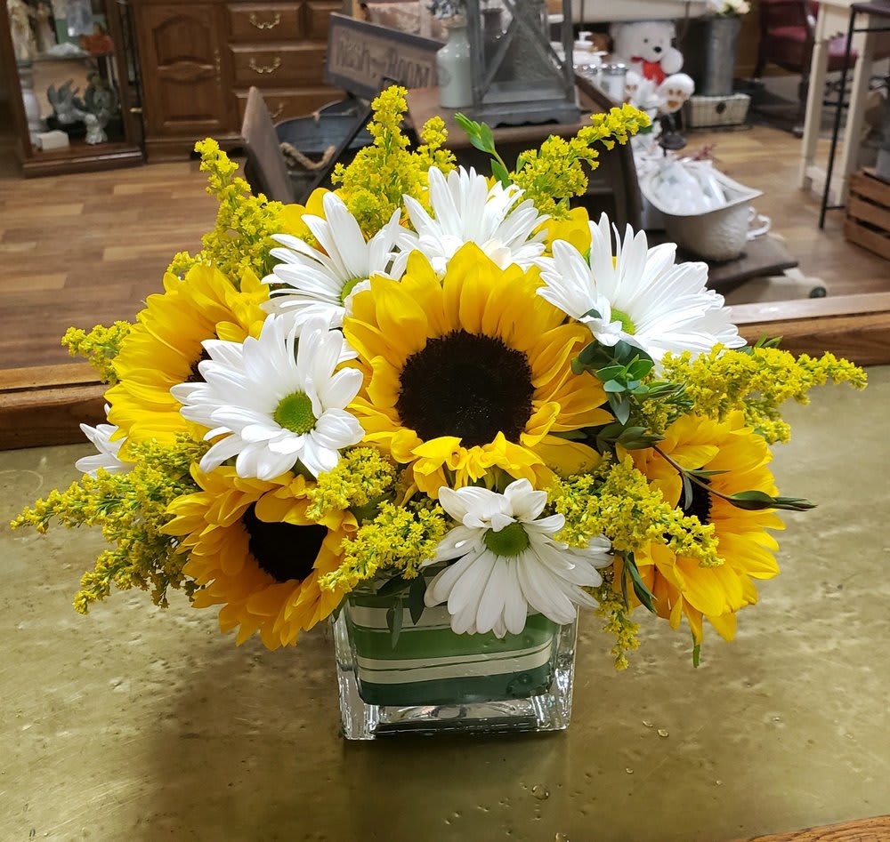 Sunflowers and white daisies in a square glass vase