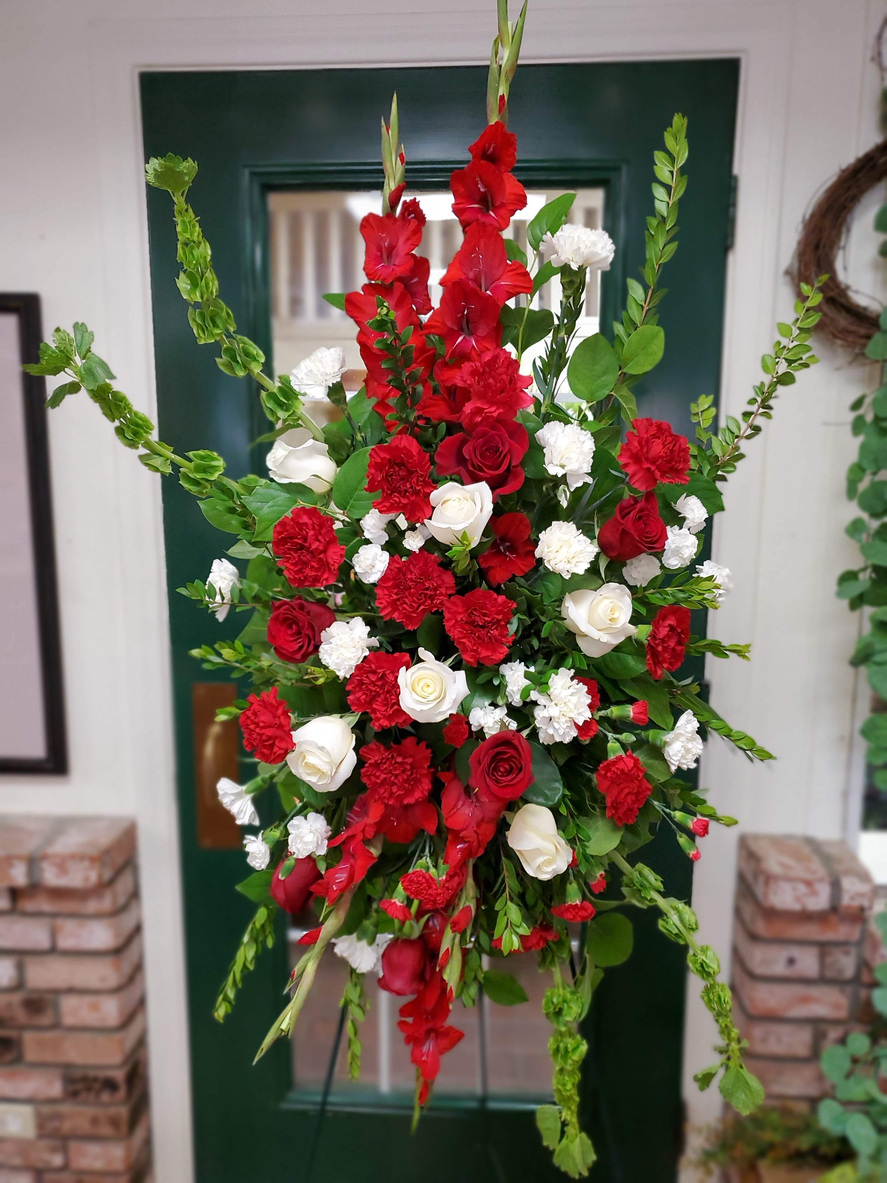 Tall red and white floral standing spray with roses and carnations
