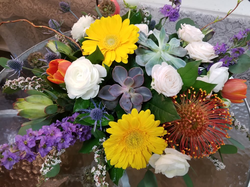 Mixed bouquet with yellow gerbera daisies, white roses, and purple flowers