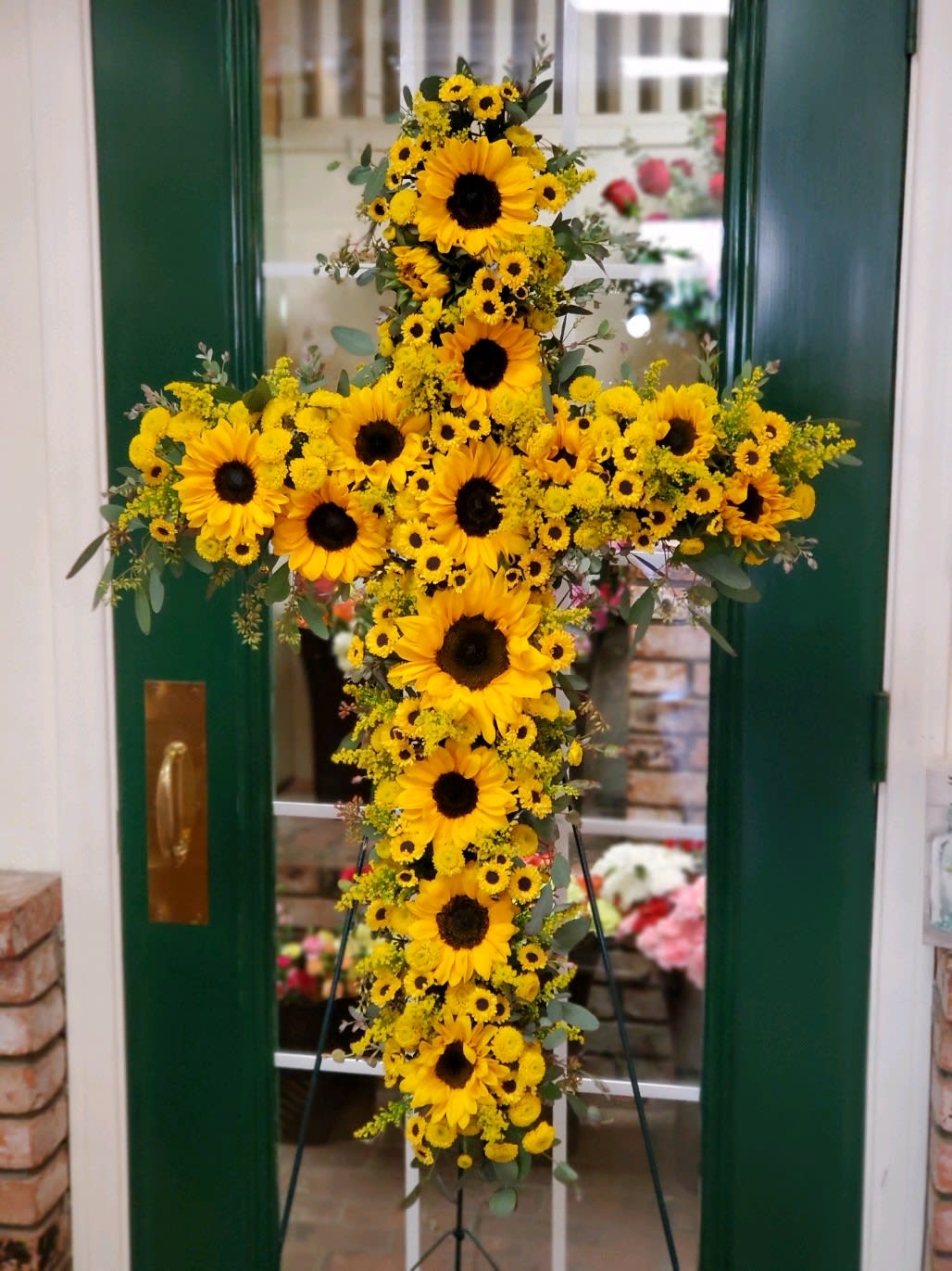 Yellow sunflower cross arrangement on a stand