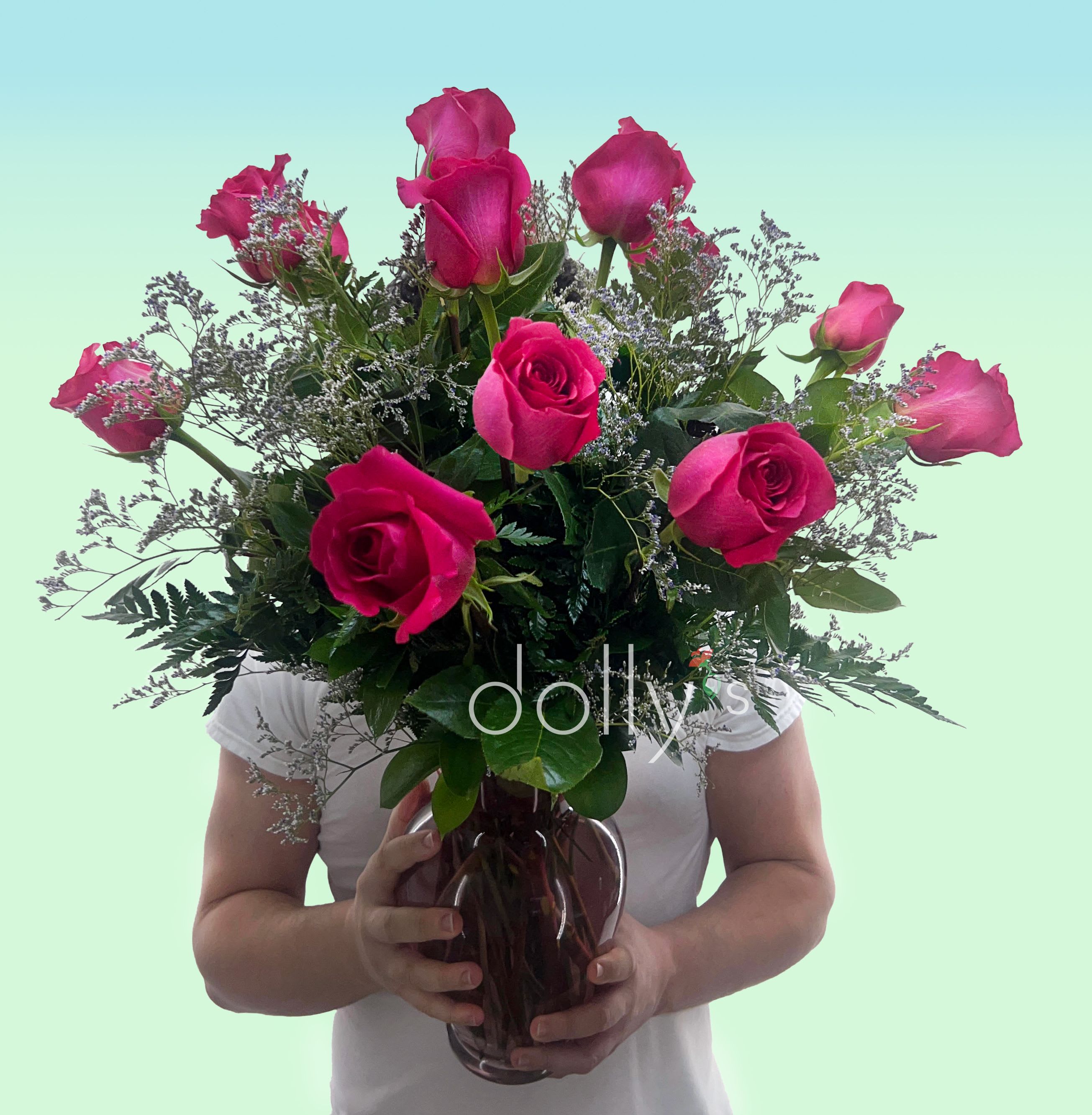 Classic Hot Pink Rose Bouquets - Vivid hot pink roses cluster into a compact, hand-tied bouquet that reads as pure joy-the perfect birthday, anniversary, or "just because" bouquet to make the person you're thinking of feel celebrated. This classic dozen hot pink rose bouquet also works beautifully for Mother's Day, an "I'm sorry" gesture, a new baby welcome, or a romantic surprise; the handheld presentation in the photo emphasizes the intimacy of gifting and the moment of connection.  A dozen roses in saturated pink form a tight dome of open blooms and a few graceful buds, their velvety petals and fresh green foliage creating a lively contrast against cool blue-green tones. The stems are gathered neatly for easy holding or arranging at home; no vase or wrapping is included so the recipient can place them straight into their favorite vessel. These roses deliver a strong visual and emotional impact while staying timeless enough for Valentine's Day, thank-you gifts, or simply to say "thinking of you."