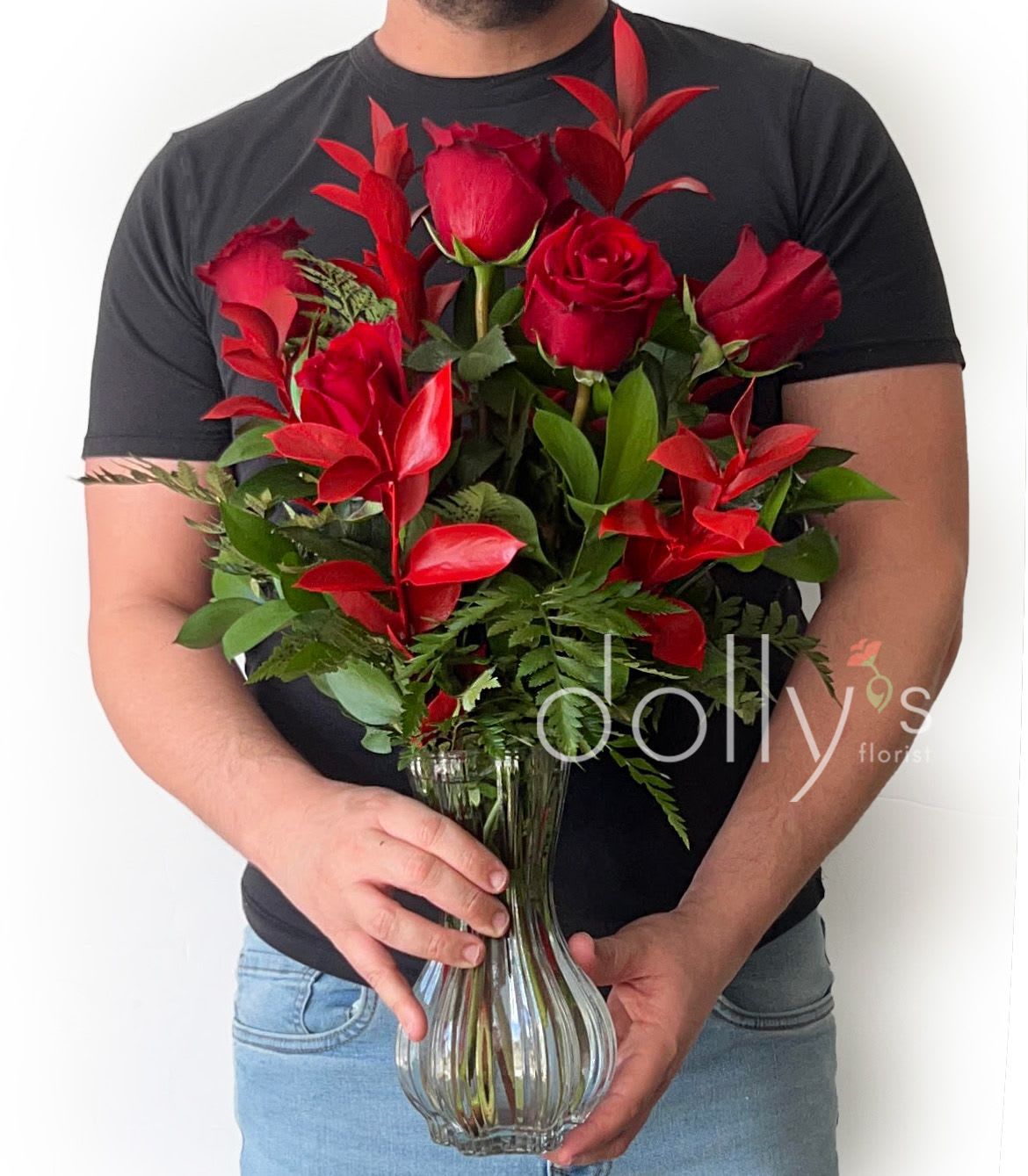 Red roses arranged in a clear glass vase