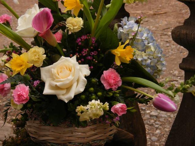 Basket arrangement with roses, tulips, daffodils, and hydrangea