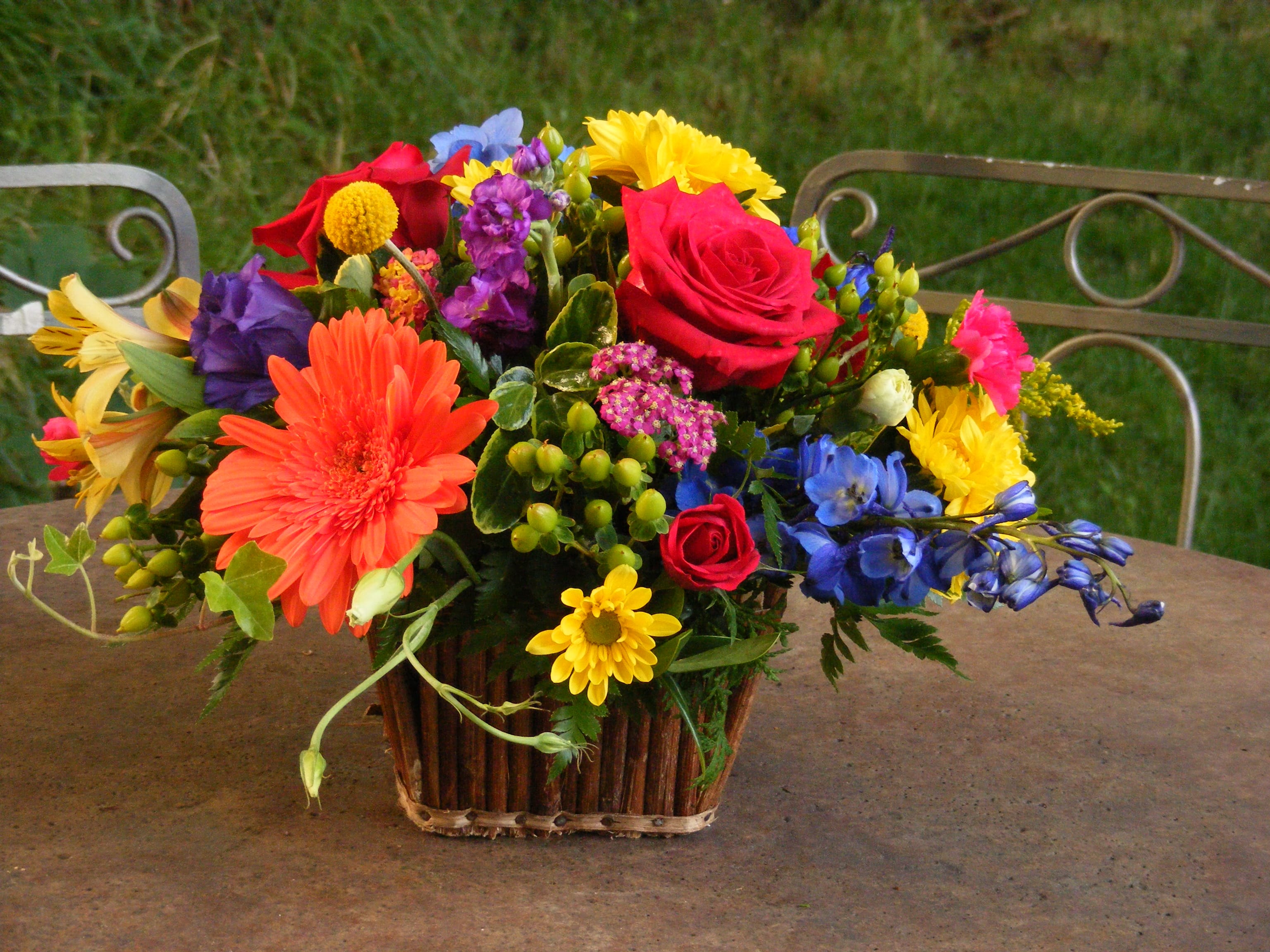 Colorful mixed flower arrangement in a basket on a table
