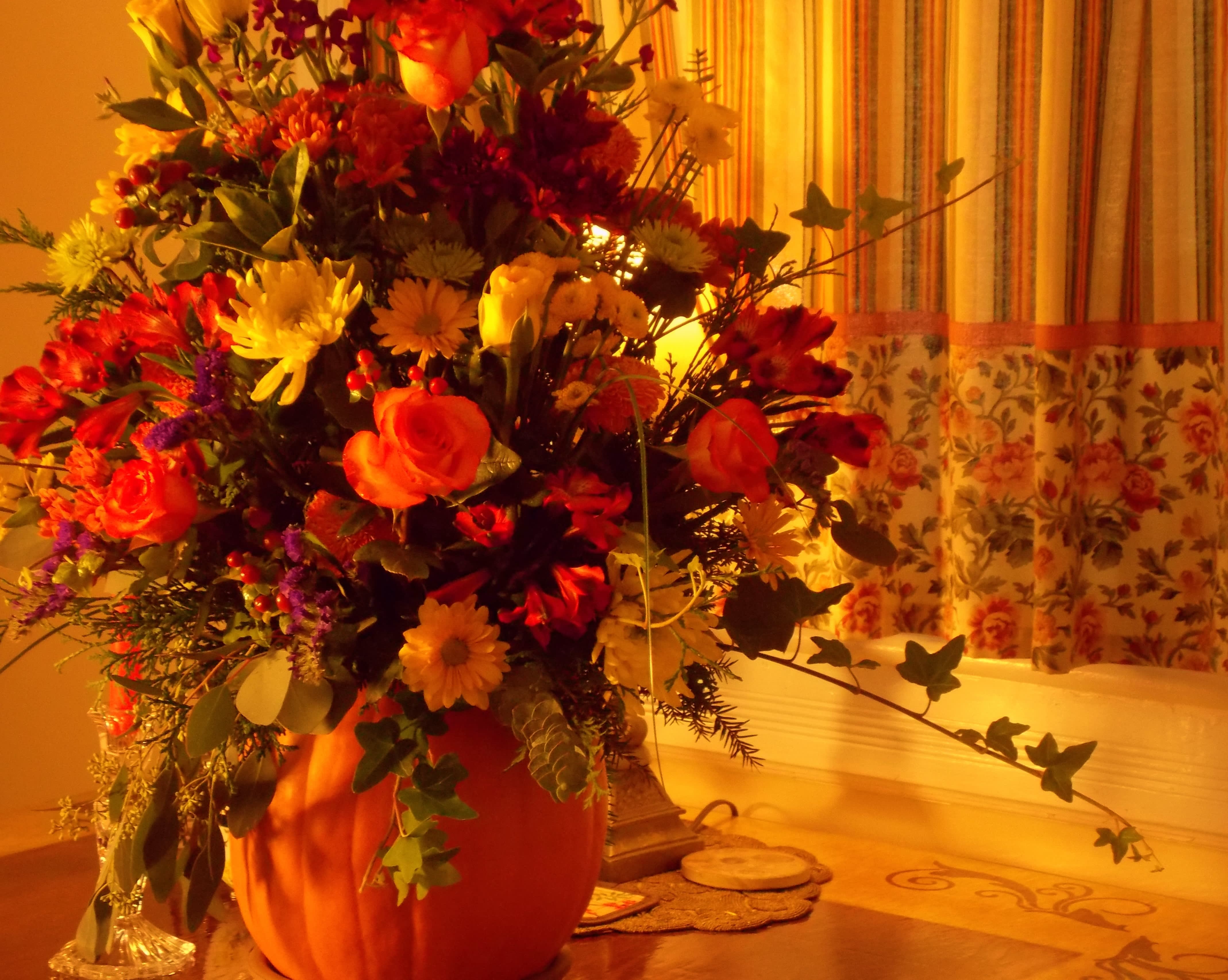 Large mixed flower arrangement in a pumpkin-shaped container