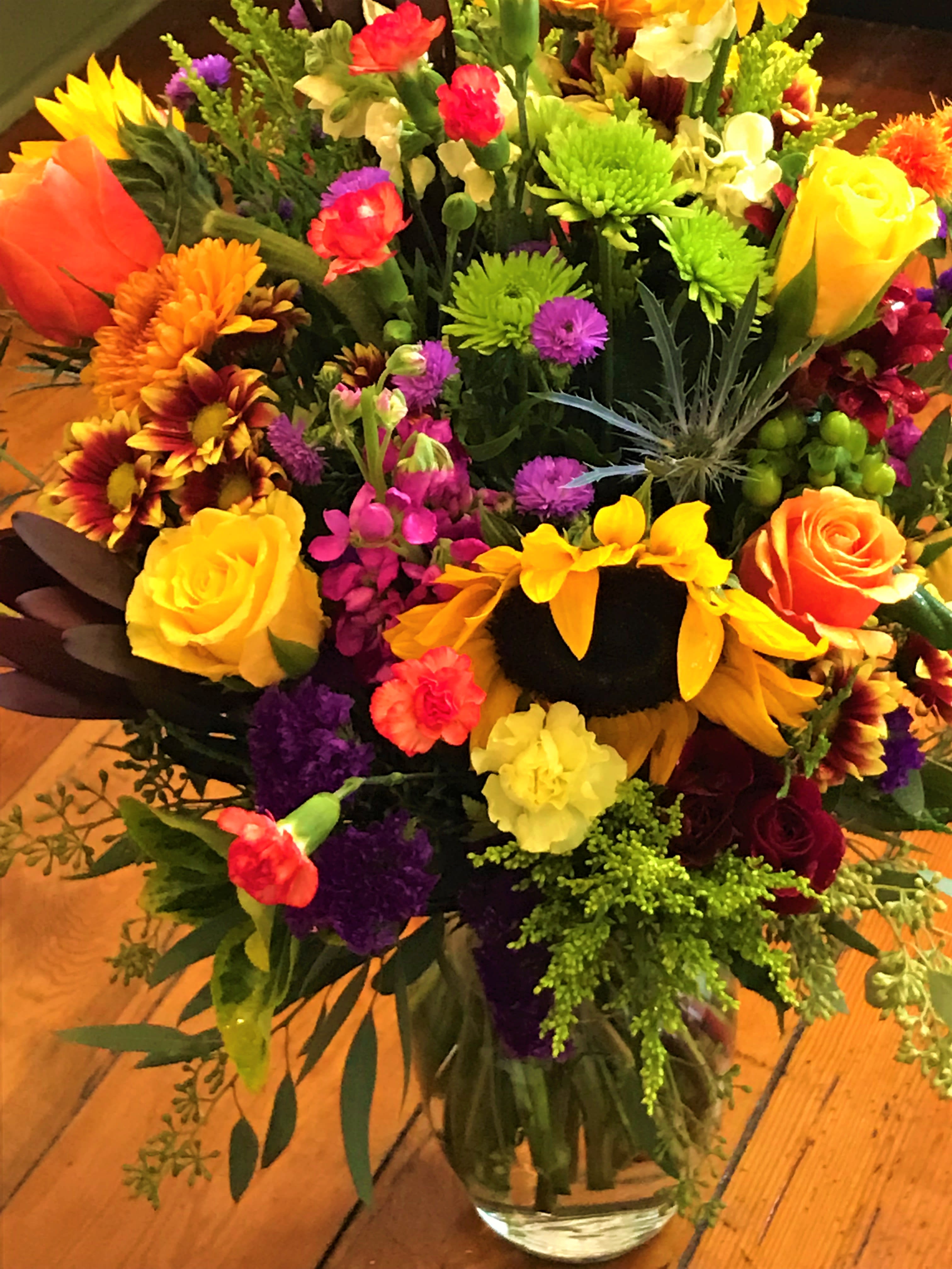 Mixed bouquet of bright flowers in a glass vase