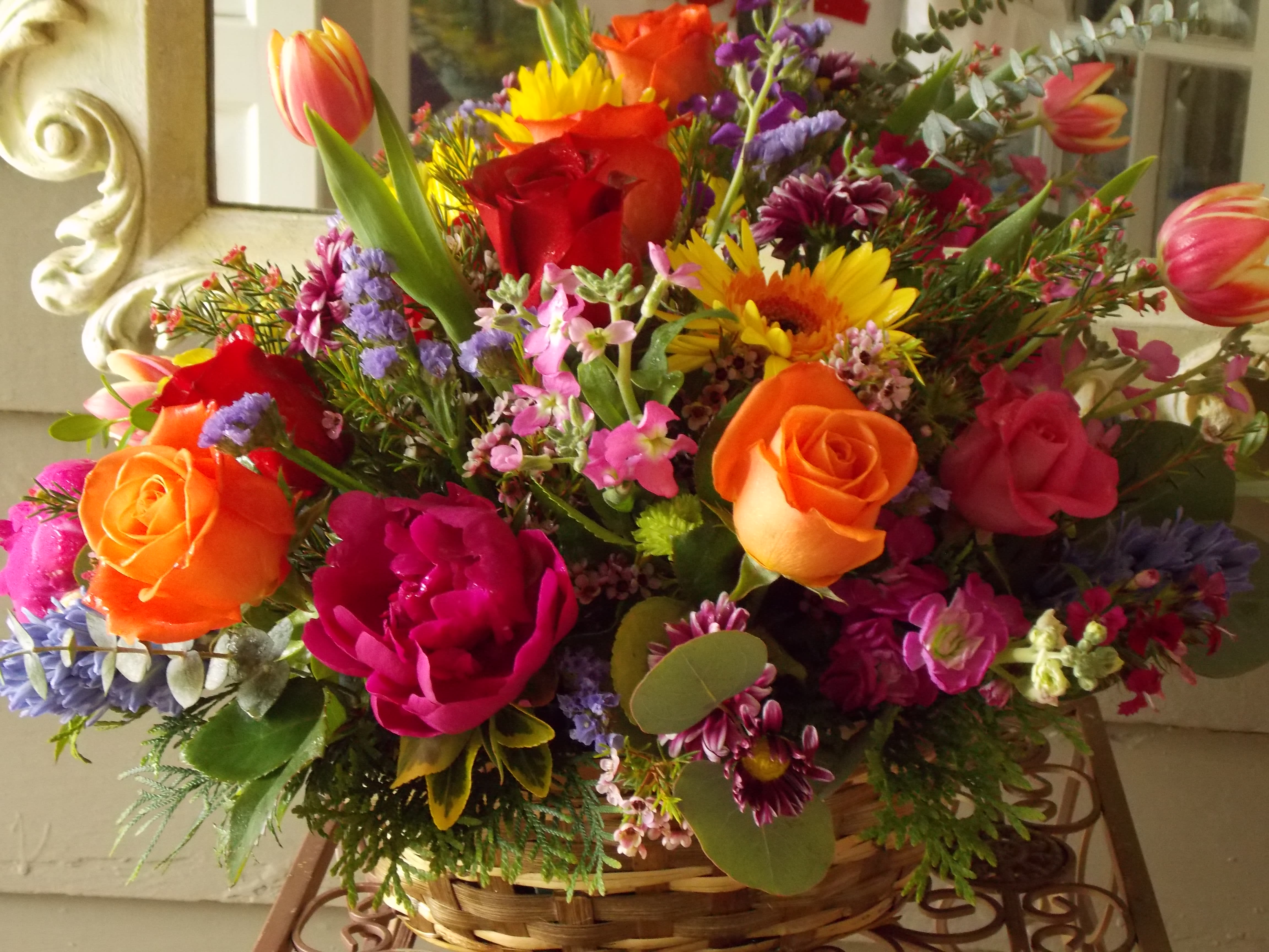 Colorful mixed flower arrangement in a wicker basket