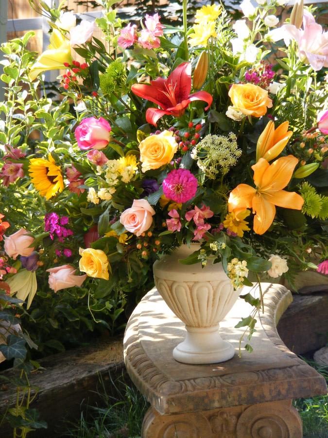 Colorful mixed flower arrangement in a cream urn vase