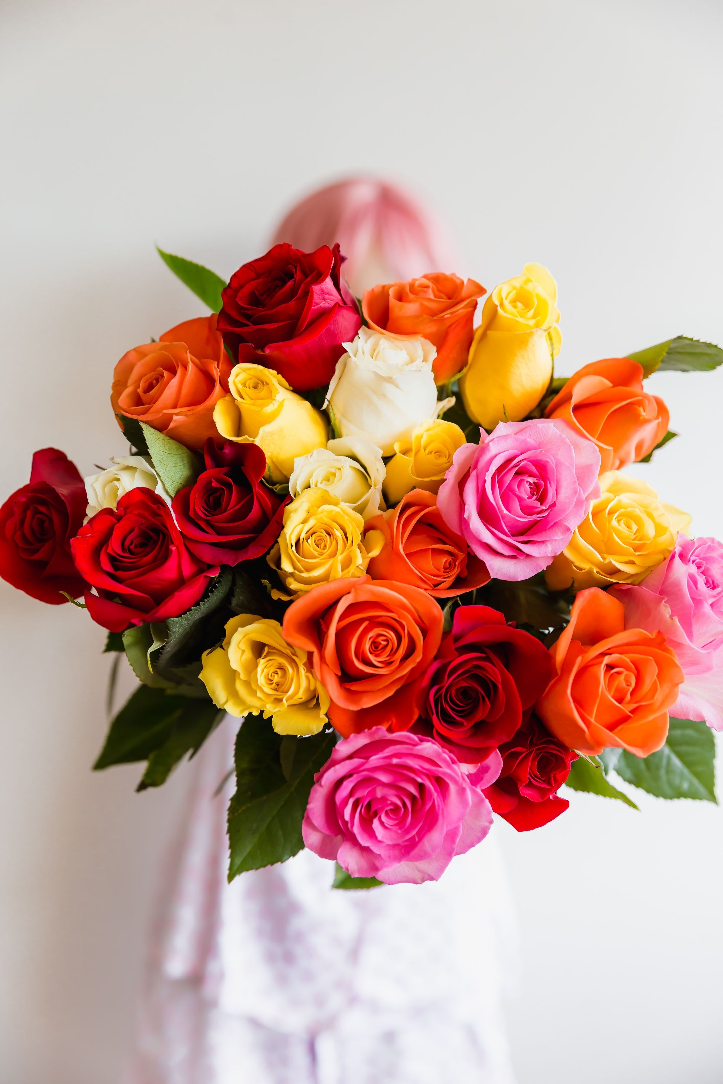 Bouquet of multicolored roses with a pink ribbon