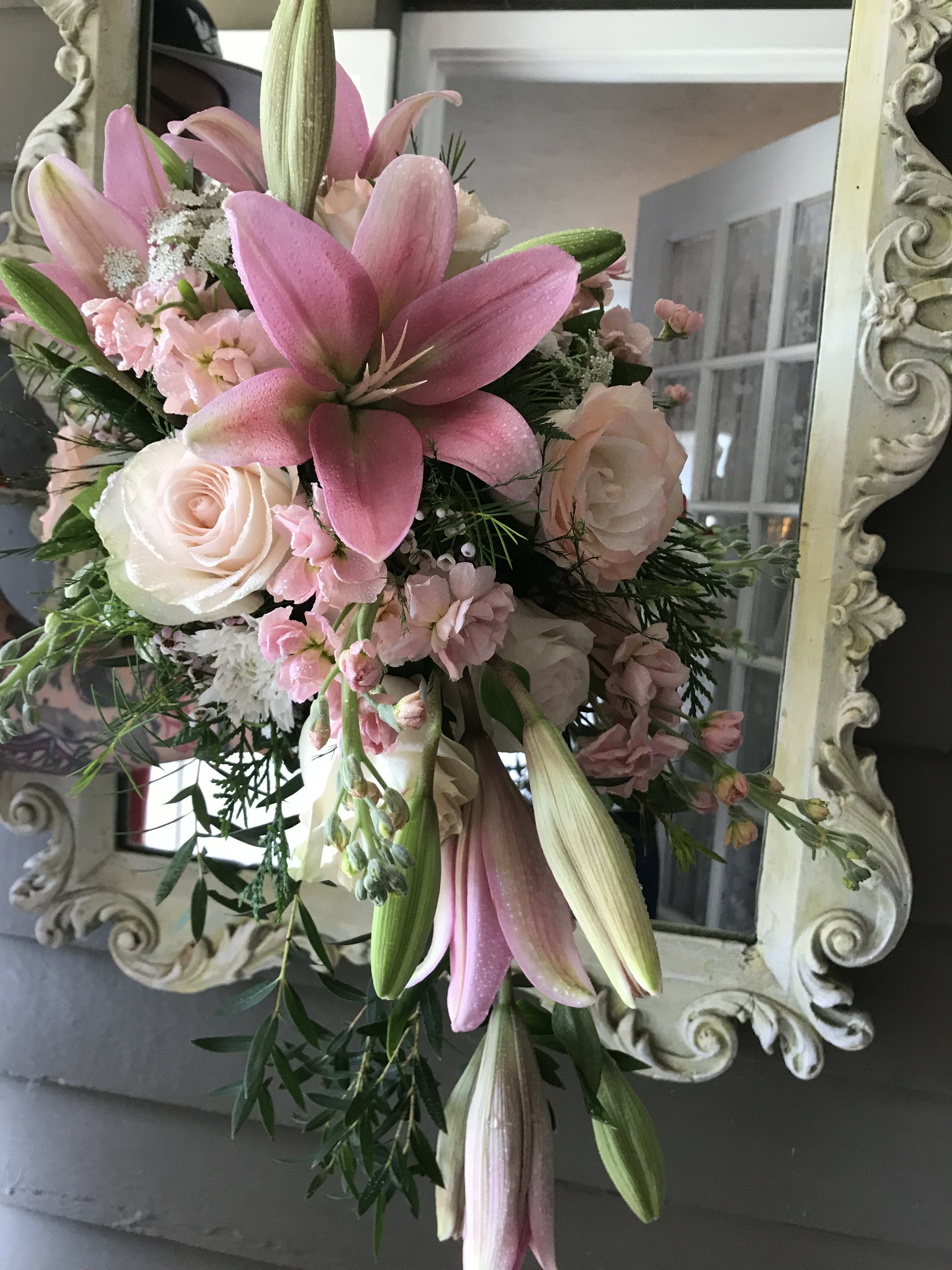 Pink lilies and pale roses in a hand-tied bouquet