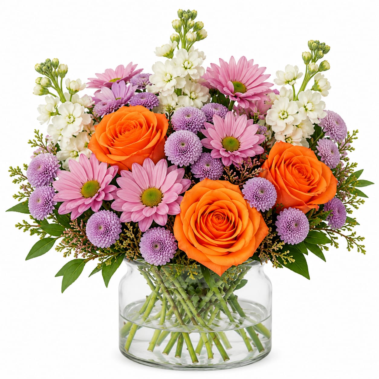 Sunset Garden Glow - Bright, cheerful, and full of life — this vibrant arrangement is designed to instantly lift the mood and stand out. Featuring 3 bold orange roses as the focal point, surrounded by soft pink daisy mums, delicate lavender button mums, and fragrant white stock, this design delivers a perfect mix of color, texture, and freshness.  The warm orange tones bring energy and excitement, while the soft pinks and lavenders create a balanced, garden-inspired feel. Finished with crisp white stock for height and elegance, this arrangement feels both playful and polished — making it a top pick for any occasion.
