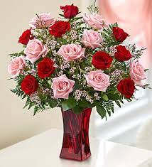 Bouquet of red and pink roses in a red glass vase