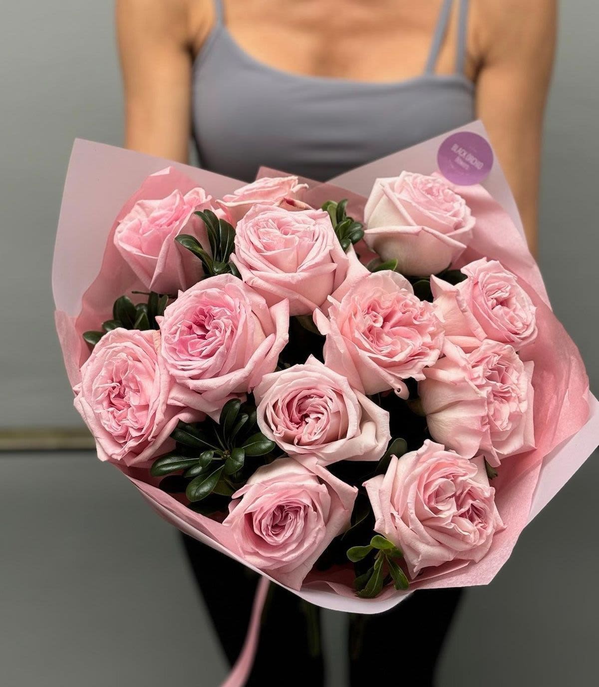 Bouquet of pale pink roses wrapped in pink paper