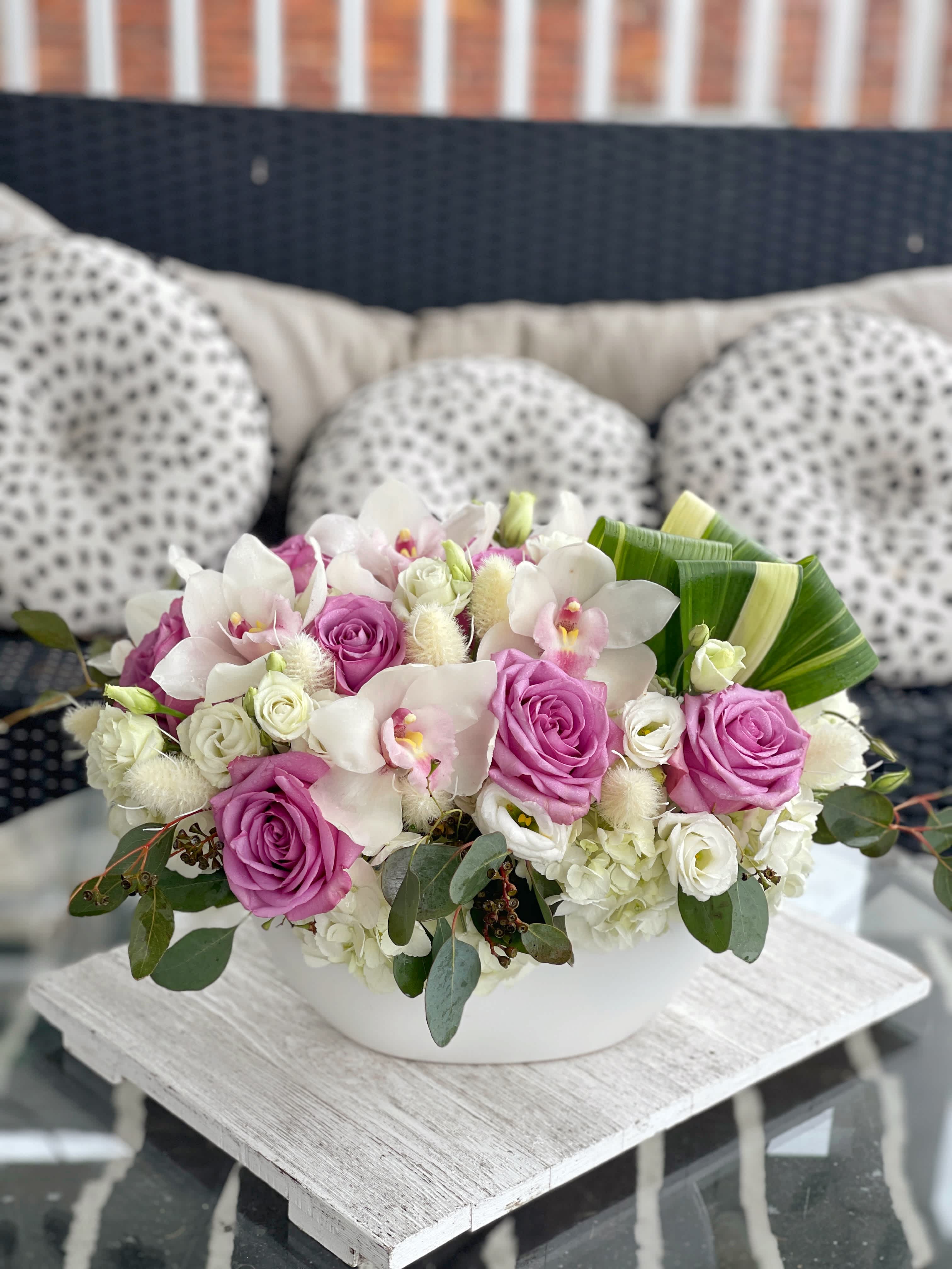 Ethereal Symphony - Discover the epitome of natural beauty and refined elegance with our "Ethereal Symphony" floral arrangement. This exquisite bouquet combines the finest blooms and accents to create a harmonious blend of colors, textures, and fragrances that captivate the senses.  At the heart of this stunning arrangement are the premium hydrangeas, known for their lush, voluminous blooms that add a soft and serene touch. Nestled among the hydrangeas are delicate cymbidium orchids, whose exotic charm and intricate petals bring an element of sophistication to the composition.  The bouquet also features romantic Cool Water Roses, adding a gentle splash of color and a touch of timeless grace. Lisianthus flowers contribute their graceful, ruffled blooms to the mix, enhancing the arrangement's elegance and depth.  For a touch of natural beauty, aspidistra leaves provide lush greenery and a striking contrast to the delicate blooms. Seeded eucalyptus adds an aromatic freshness and a hint of rustic charm, while dried accents introduce a unique textural dimension that complements the arrangement's overall aesthetic.  Expertly arranged by our talented florists, the "Ethereal Symphony" is presented in a sleek, modern vase that enhances its allure. Perfect for special occasions, celebrations, or as a thoughtful gift for someone special, this arrangement is sure to leave a lasting impression.  Elevate any space with the mesmerizing beauty of the "Ethereal Symphony" floral arrangement. 