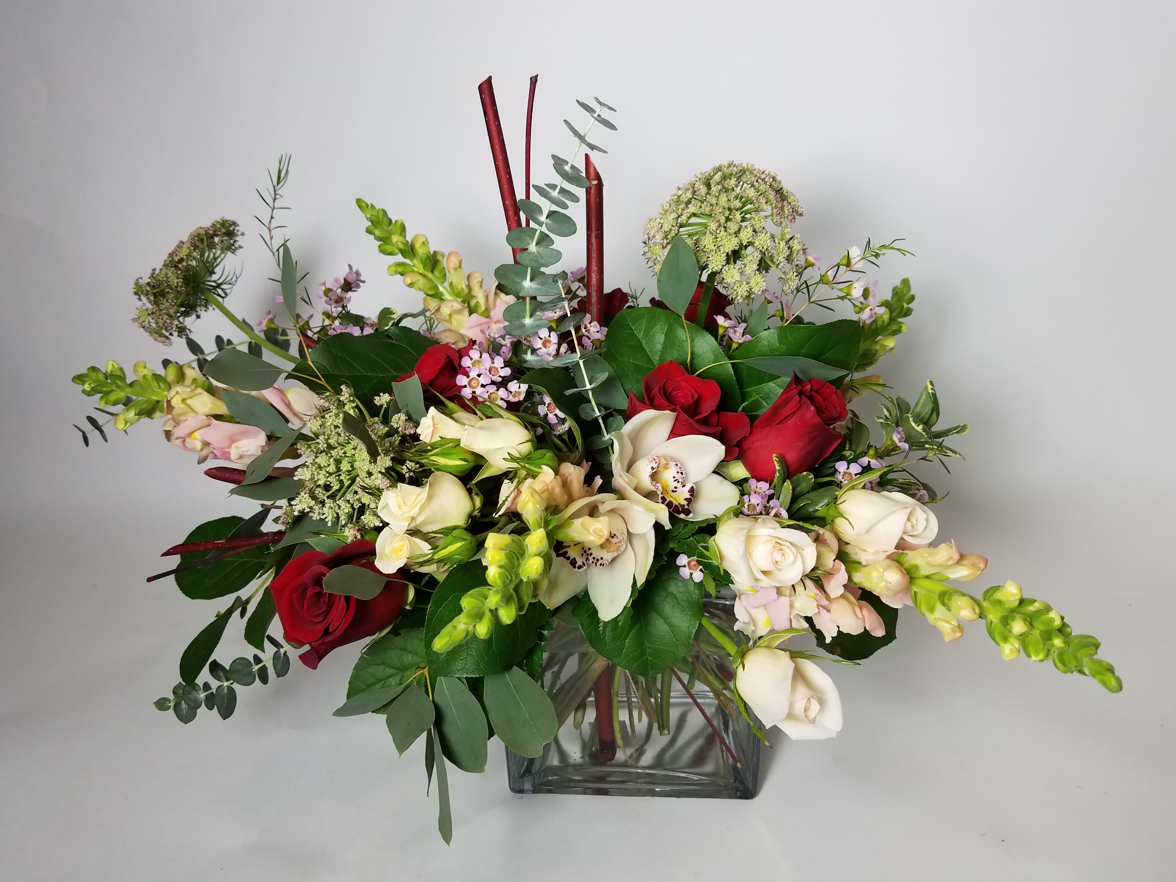 Mixed bouquet of red and white flowers in a clear glass vase