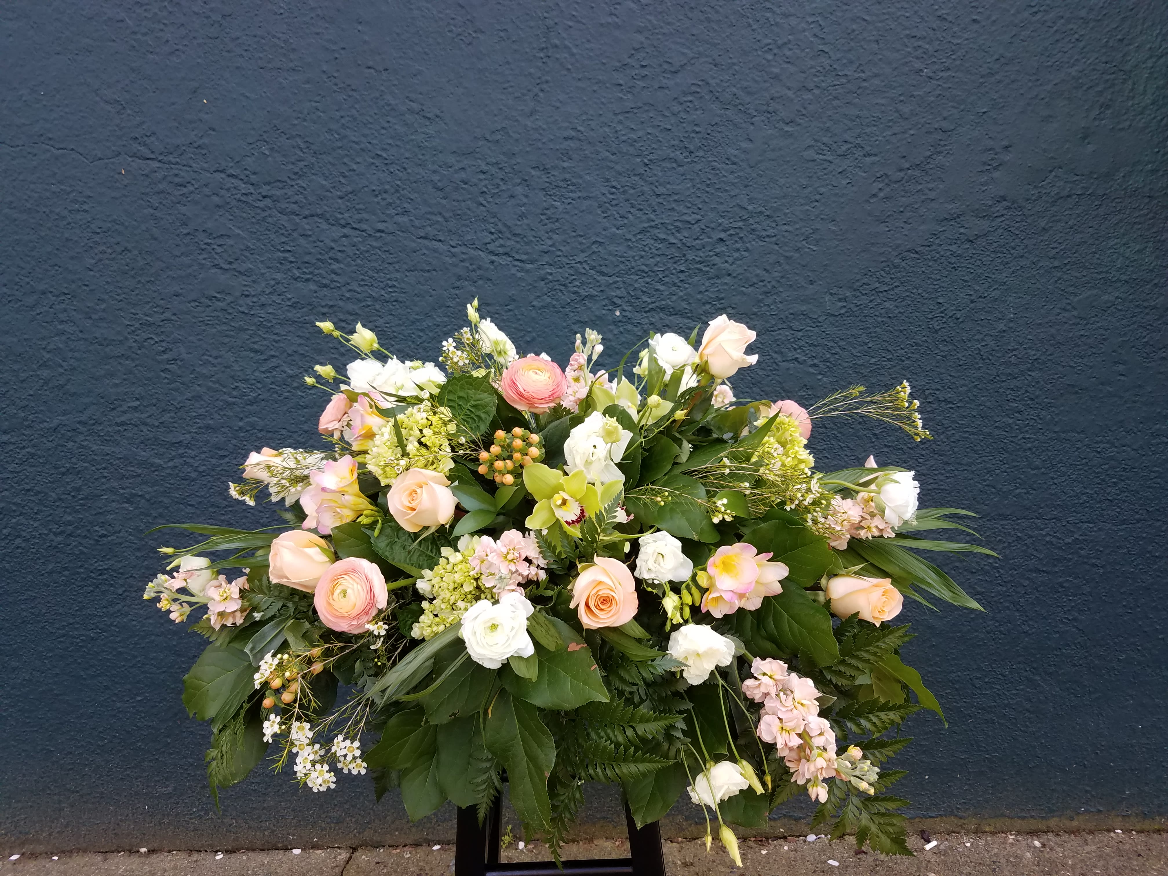 Large pastel floral arrangement with roses and white blooms