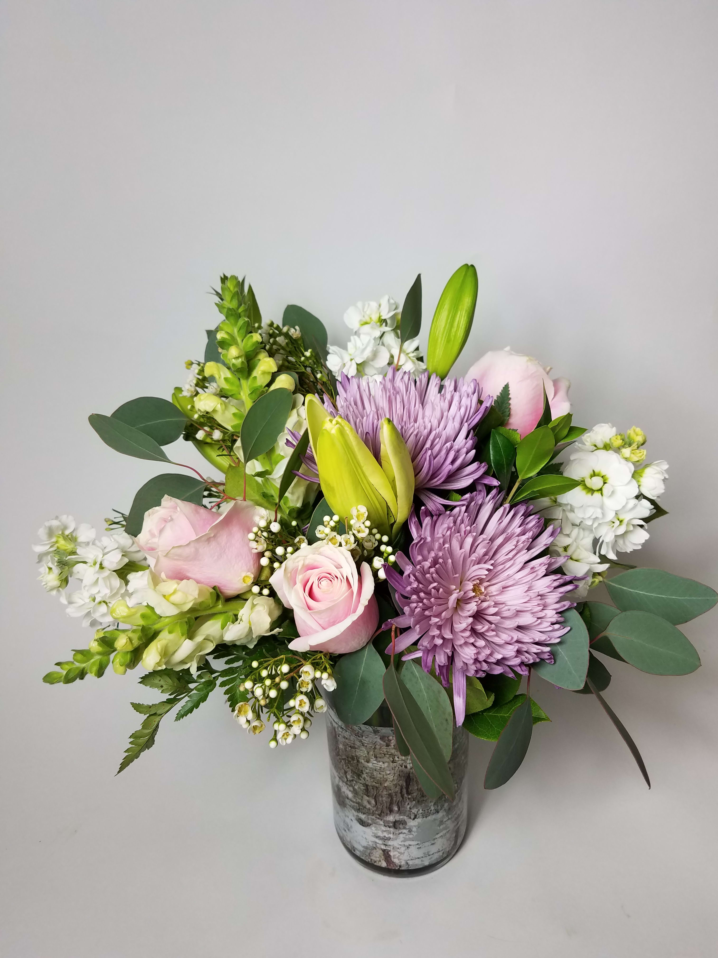 Pink roses and purple chrysanthemums in a glass vase