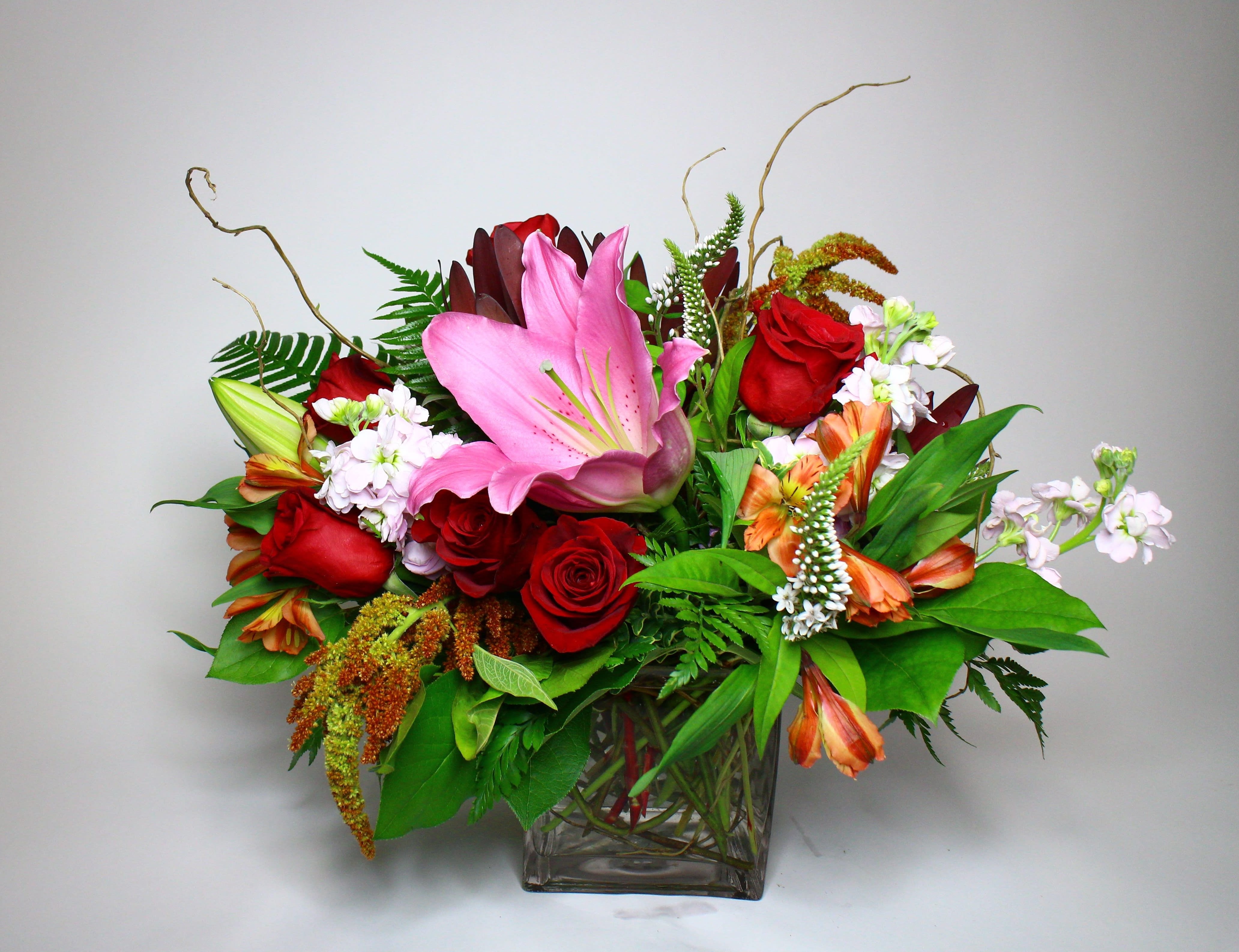 Mixed bouquet with pink lilies and red roses in a glass vase