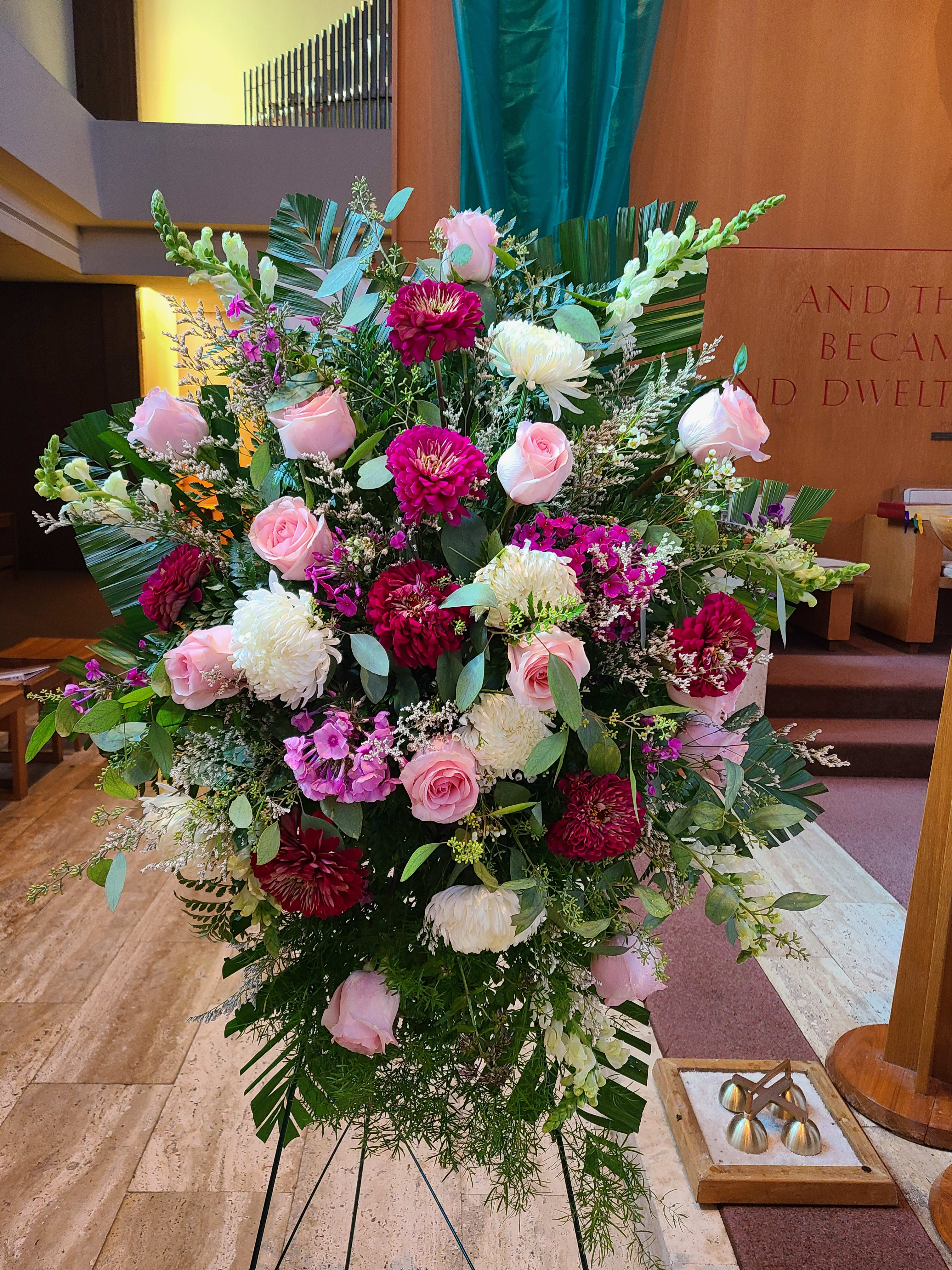 Large pink and white floral arrangement on a stand