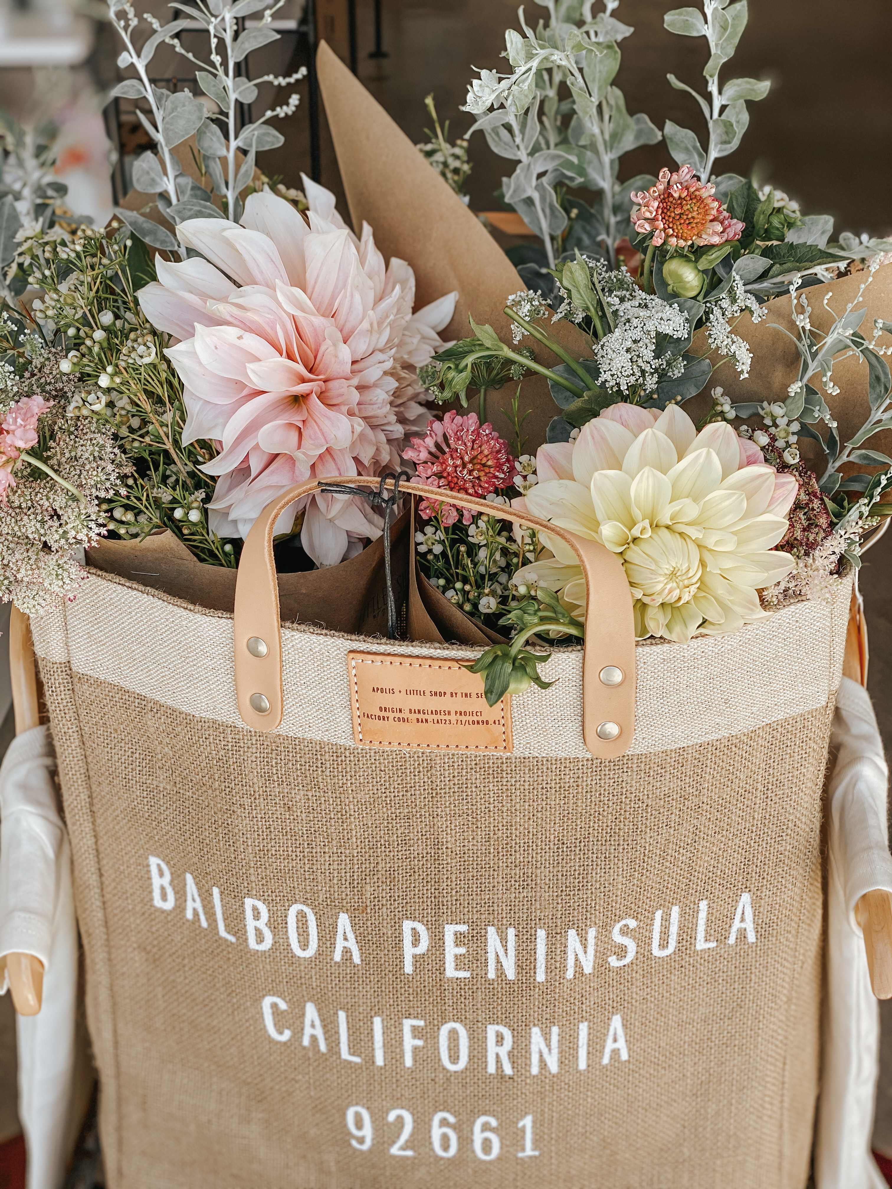 Two pastel flower bouquets in a burlap tote bag