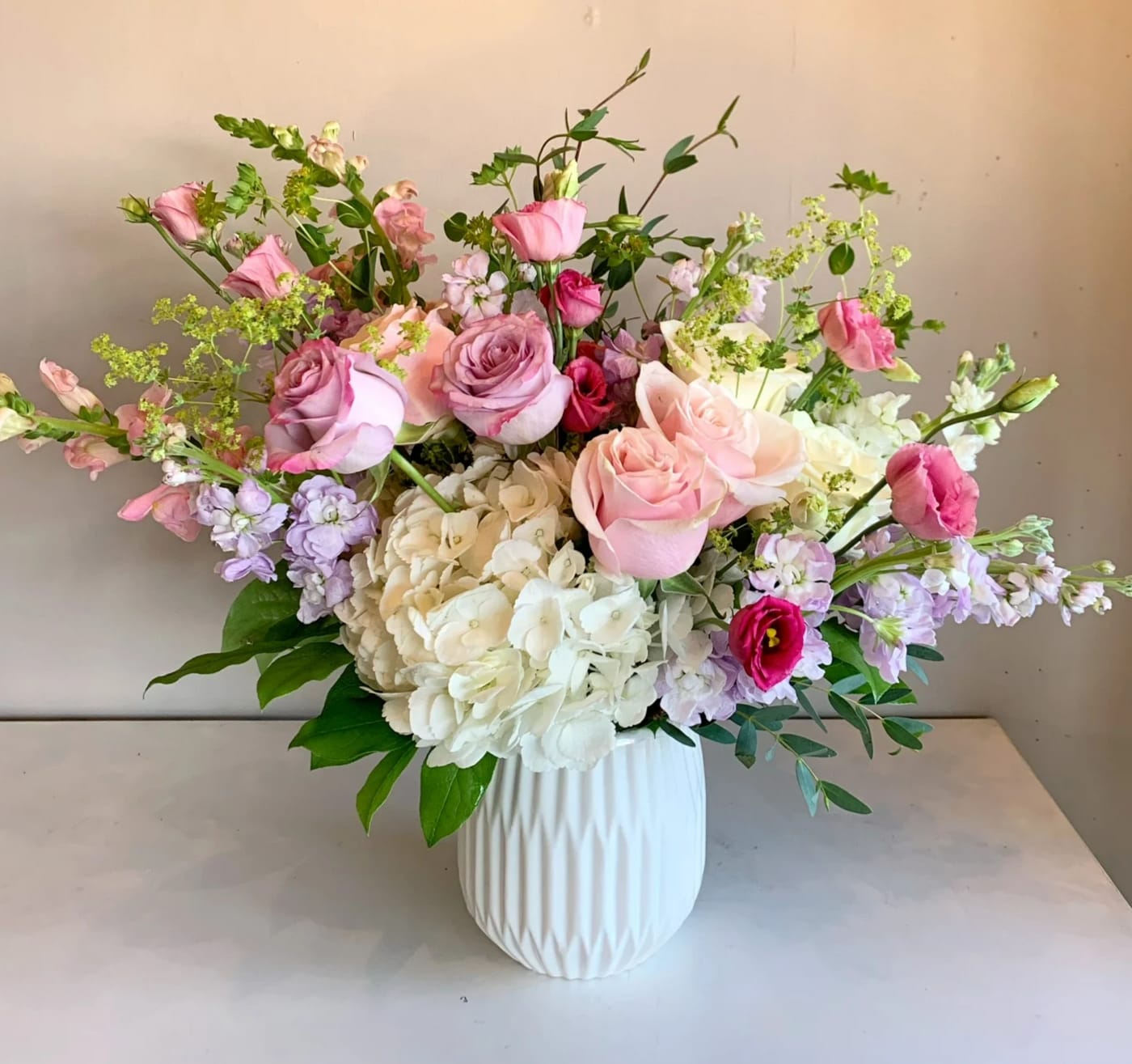Pink and white rose bouquet in a white vase