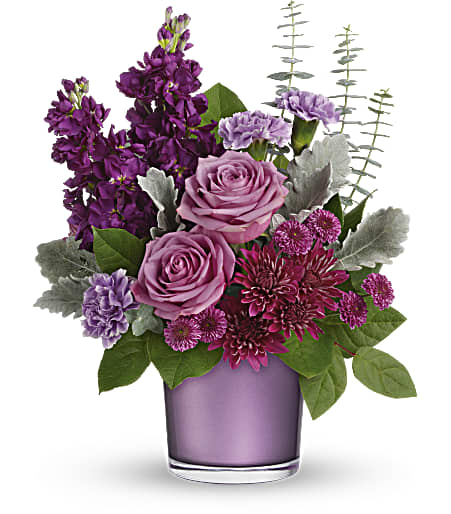 Purple and pink floral arrangement in a lavender glass vase